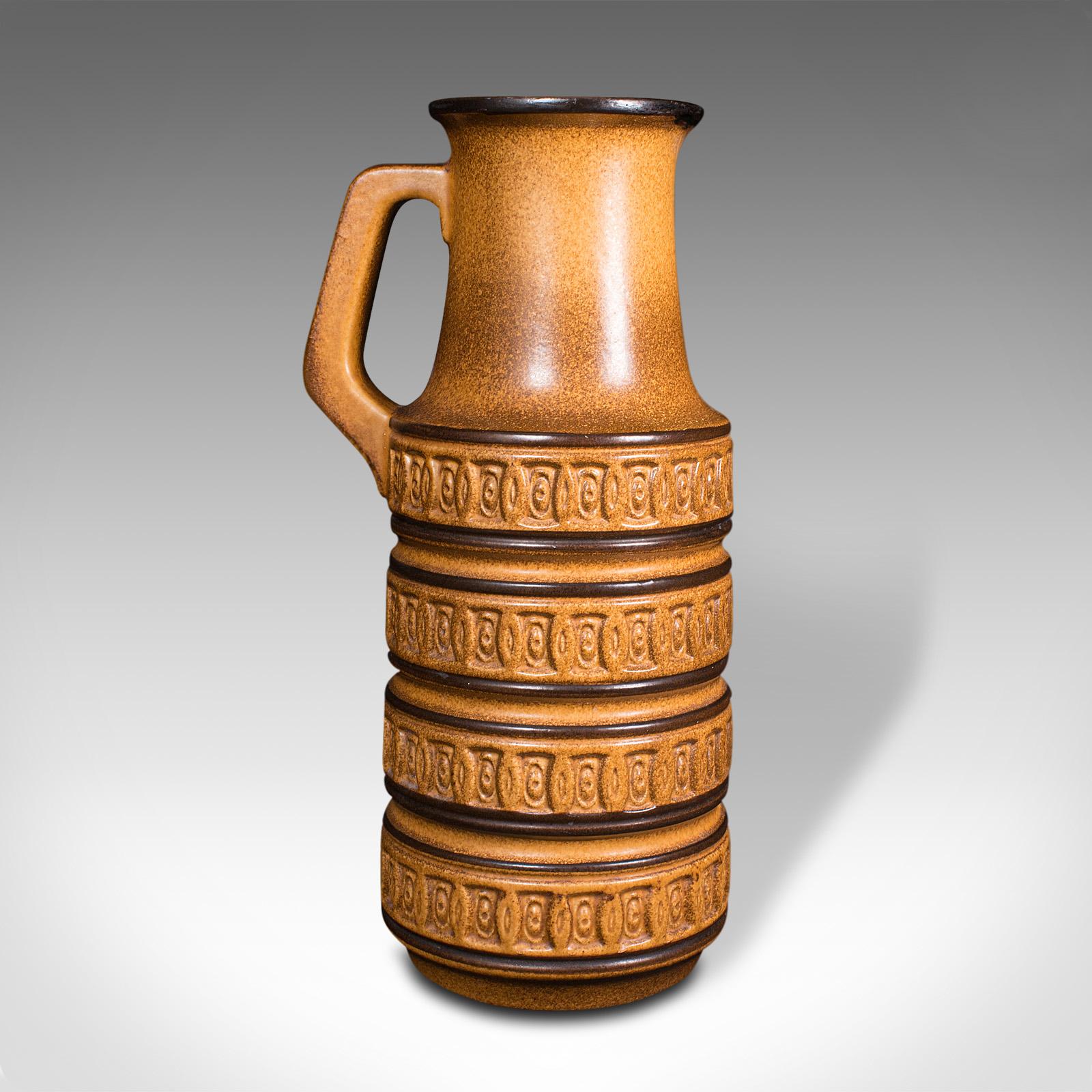 This is a tall vintage decorative jug. A German, ceramic lava pattern serving ewer or vase, dating to the late 20th century, circa 1970.

A bold, vibrant jug with an appropriately late 20th century taste
Displaying a desirable aged patina and in