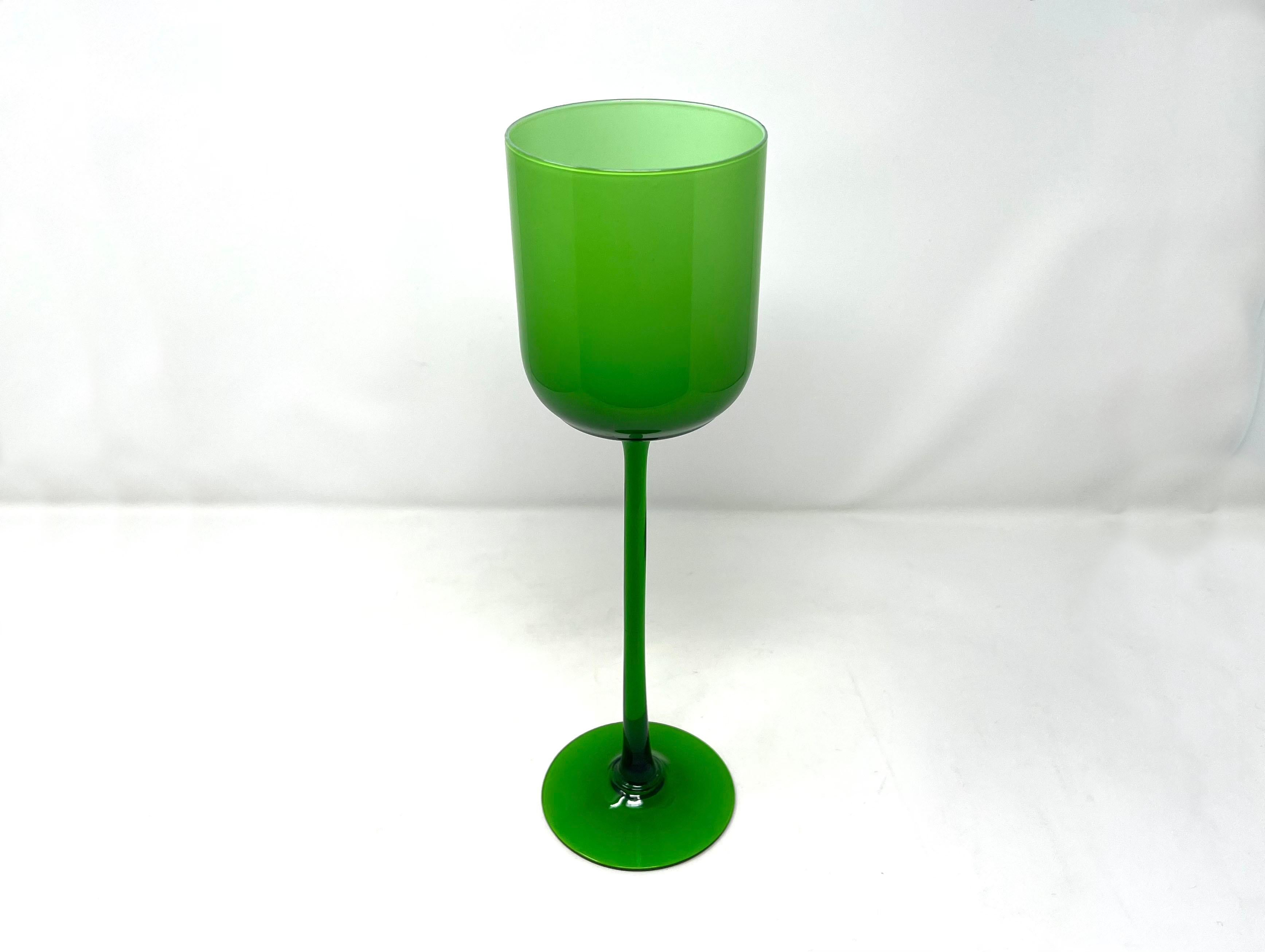 Super tall, stunning kelly green cased glass goblet. Opaque white on interior; translucent green on exterior. Graceful stem. No makers marks but possibly from the Empoli region in Italy in the 1970s. Or even Carlo Moretti.

Lovely for a collection