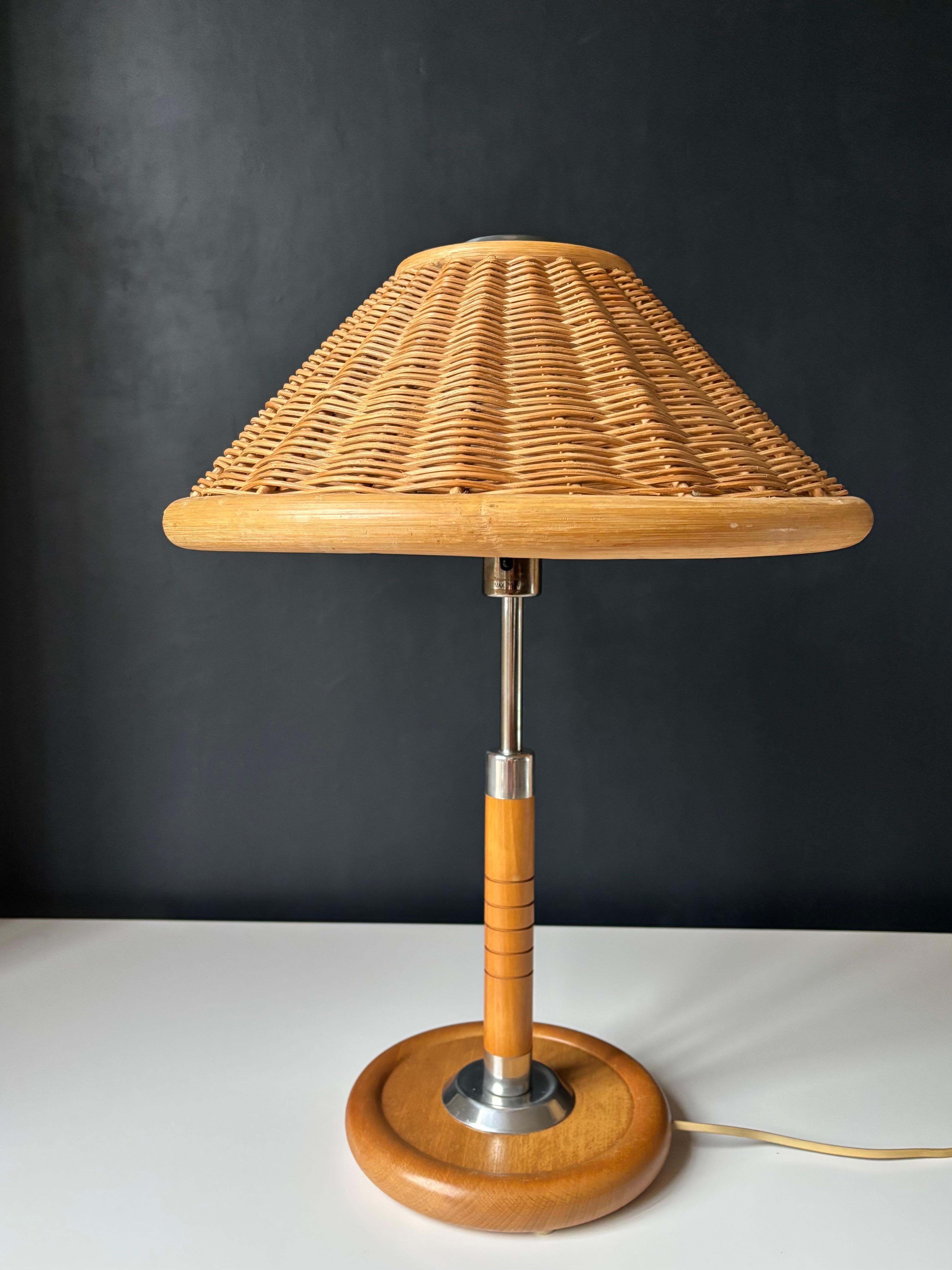 Lampada da tavolo vintage in legno, cromo e rattan. Grande paralume a forma di coolie in rattan intrecciato montato su un piano cromato lucido. Gambo in Wood e cromo su piede in legno massiccio di 23 cm. Cablato per l'utilizzo in Europa e negli