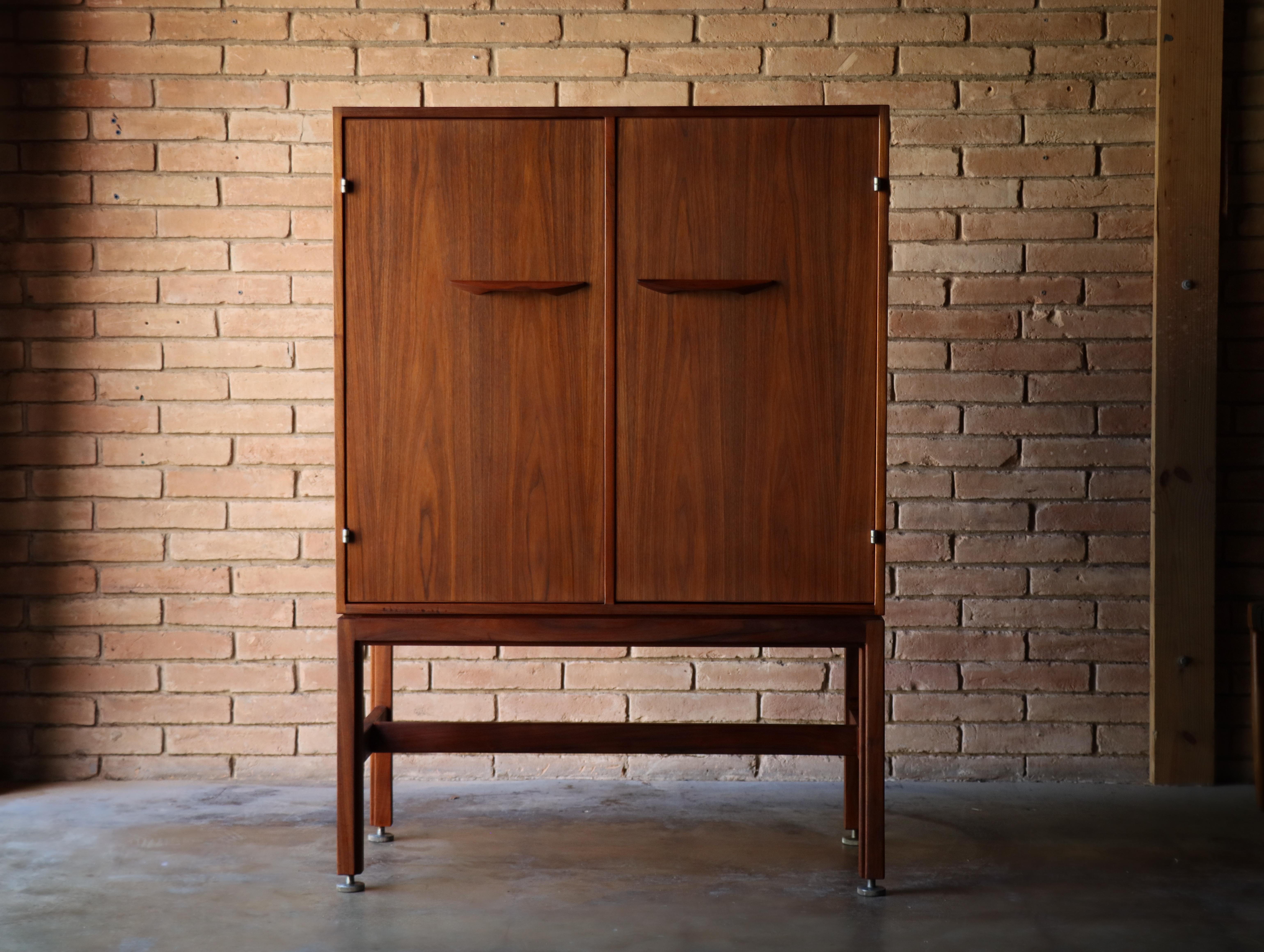 Beautiful and uncommon walnut cabinet designed by Jens Risom, 1960s. 

This particular design can be used in a number of different usages. Perhaps originally deigned to be a linen cabinet, it would also serve well as a bar cabinet, home office or to