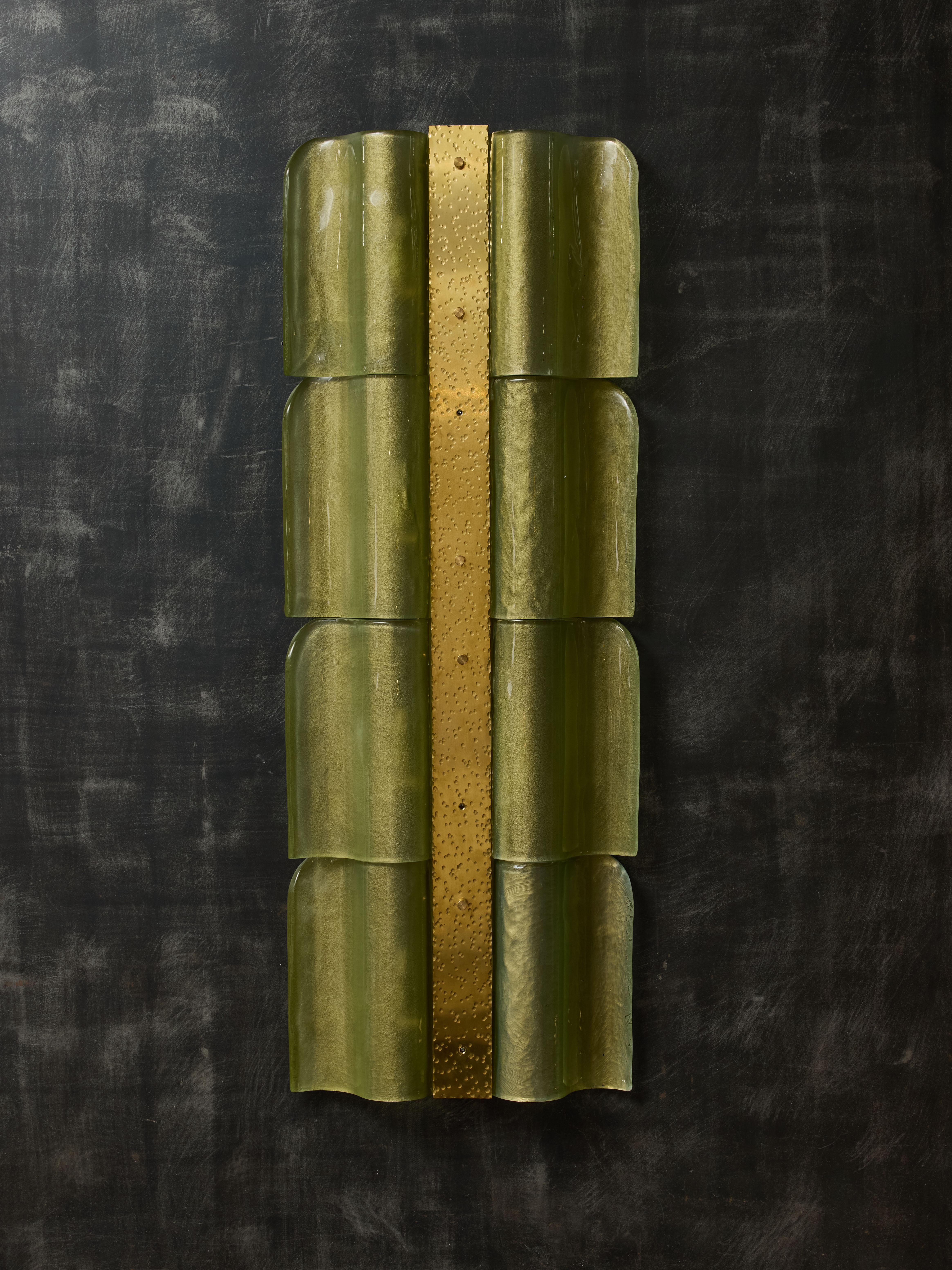 Tall wall sconces made of a central hammered brass plate, with green Murano glass panels on each side.