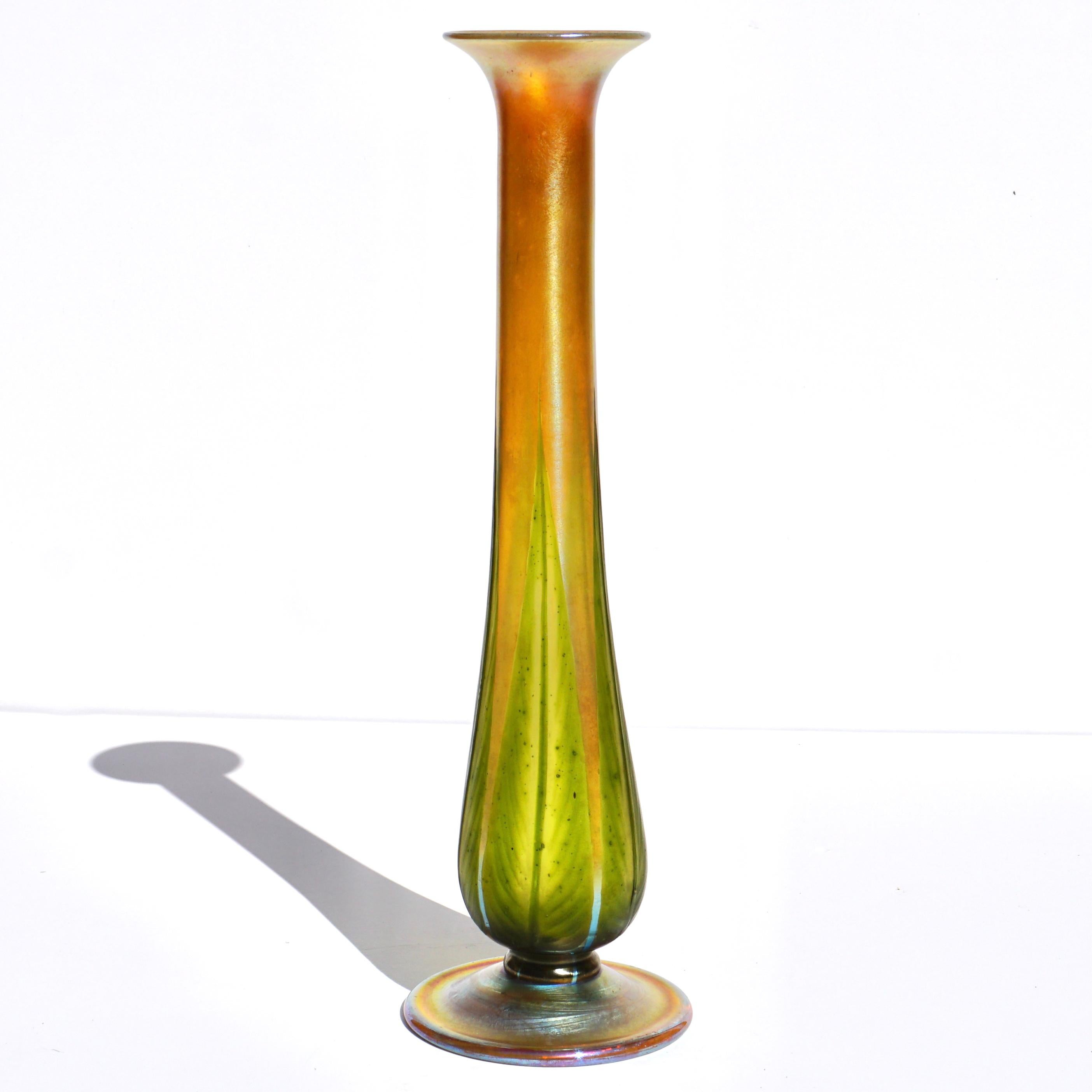 Tall Tiffany Studios wheel-carved Favrile glass leaves vase, 1918 Art Nouveau.

Marks: 7062M L.C. Tiffany Inc. Favrile

Measures: Height: 11.85 inches (29.8 cm) Diameter: 3.5 Inches

Slender footed vase with five delicately wheel-carved leaves