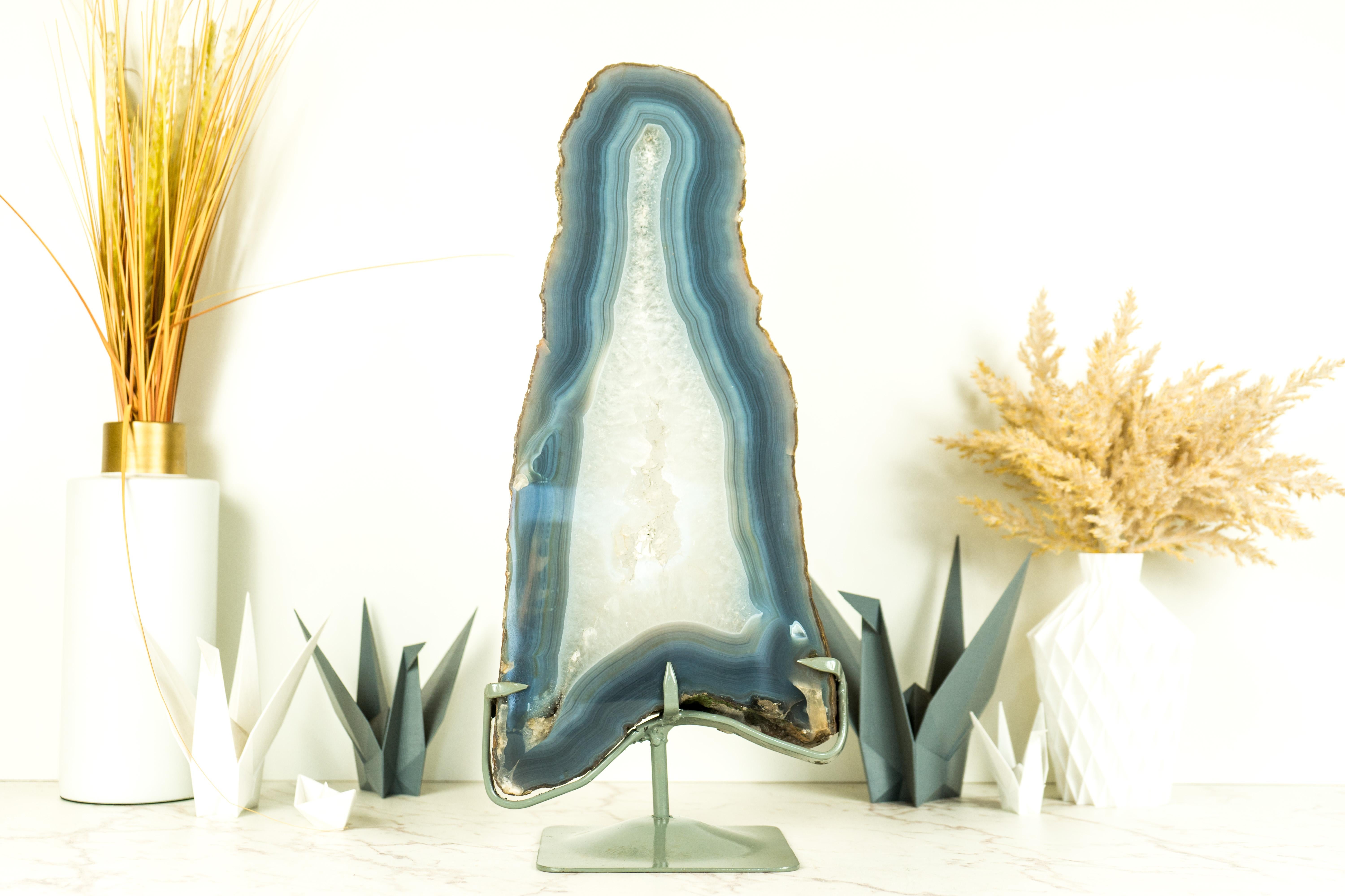 Showcasing the rare beauty of blue and white lace agate in a gorgeous tall format, this Agate Geode Slice is a natural artwork that will surely enhance your decor as a centerpiece, a large bookshelf accent, or a powerful tool in your healing arsenal