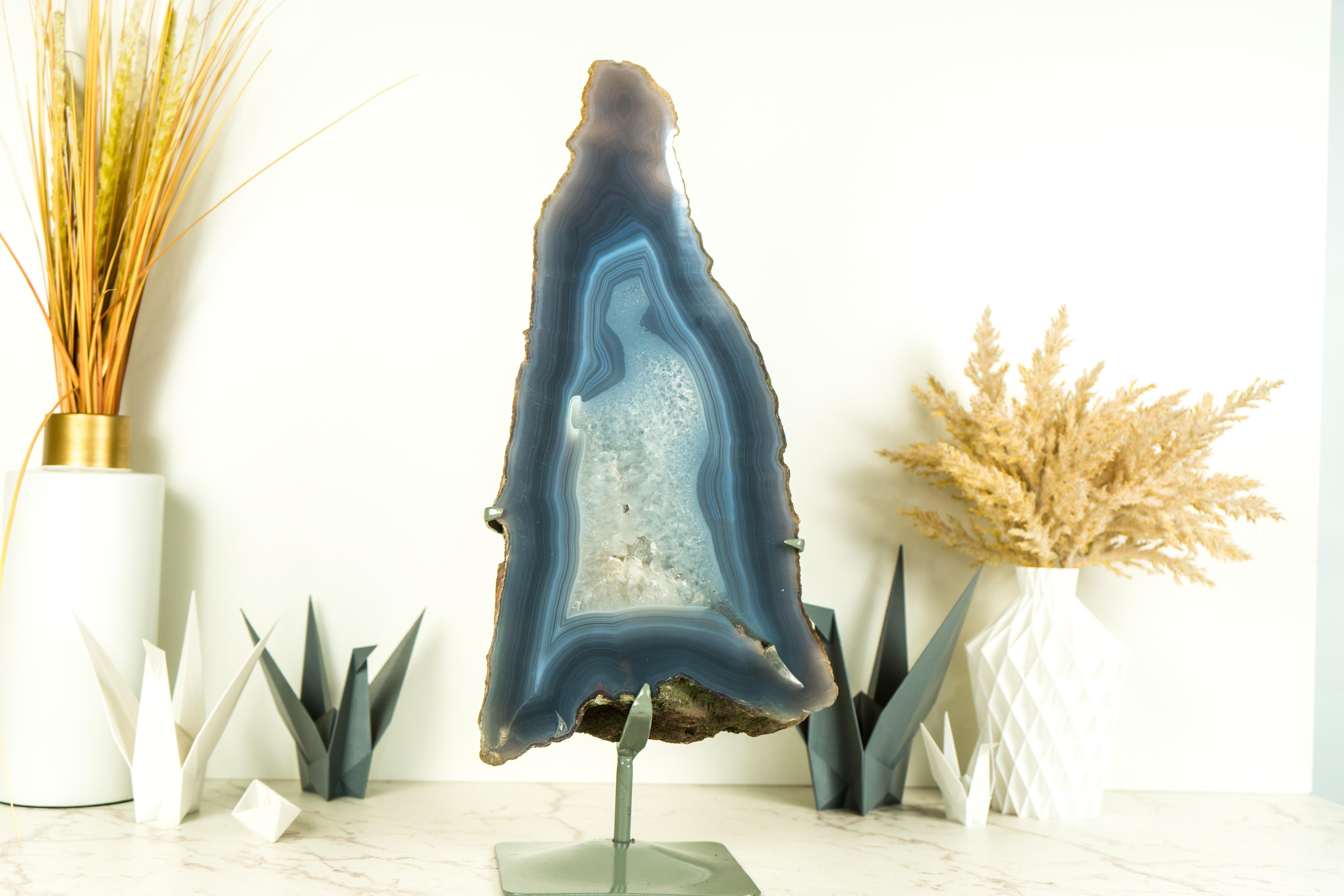 Présentant la rare beauté de l'agate dentelle bleue et blanche dans un superbe format haut, cette tranche de géode d'agate est une œuvre d'art naturelle qui ne manquera pas de rehausser votre décor en tant que pièce maîtresse, élément de