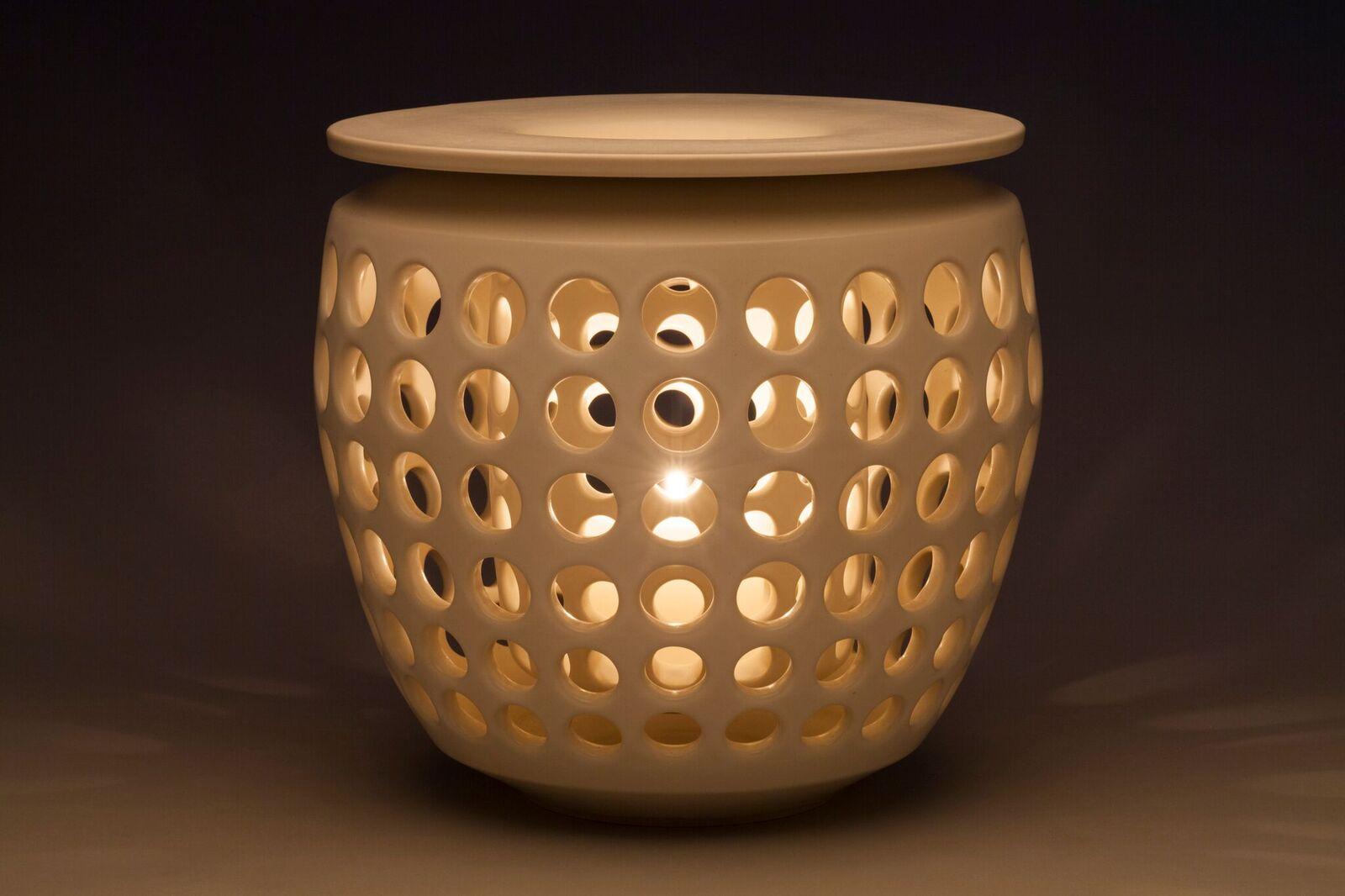 Inspired by Mid-Century Modern design, this unique candleholder is made in two pieces. A pierced outer shell holds a removable pierced insert. Both pieces wheel thrown and hand pierced white stoneware with a white satin glaze. Small holes are