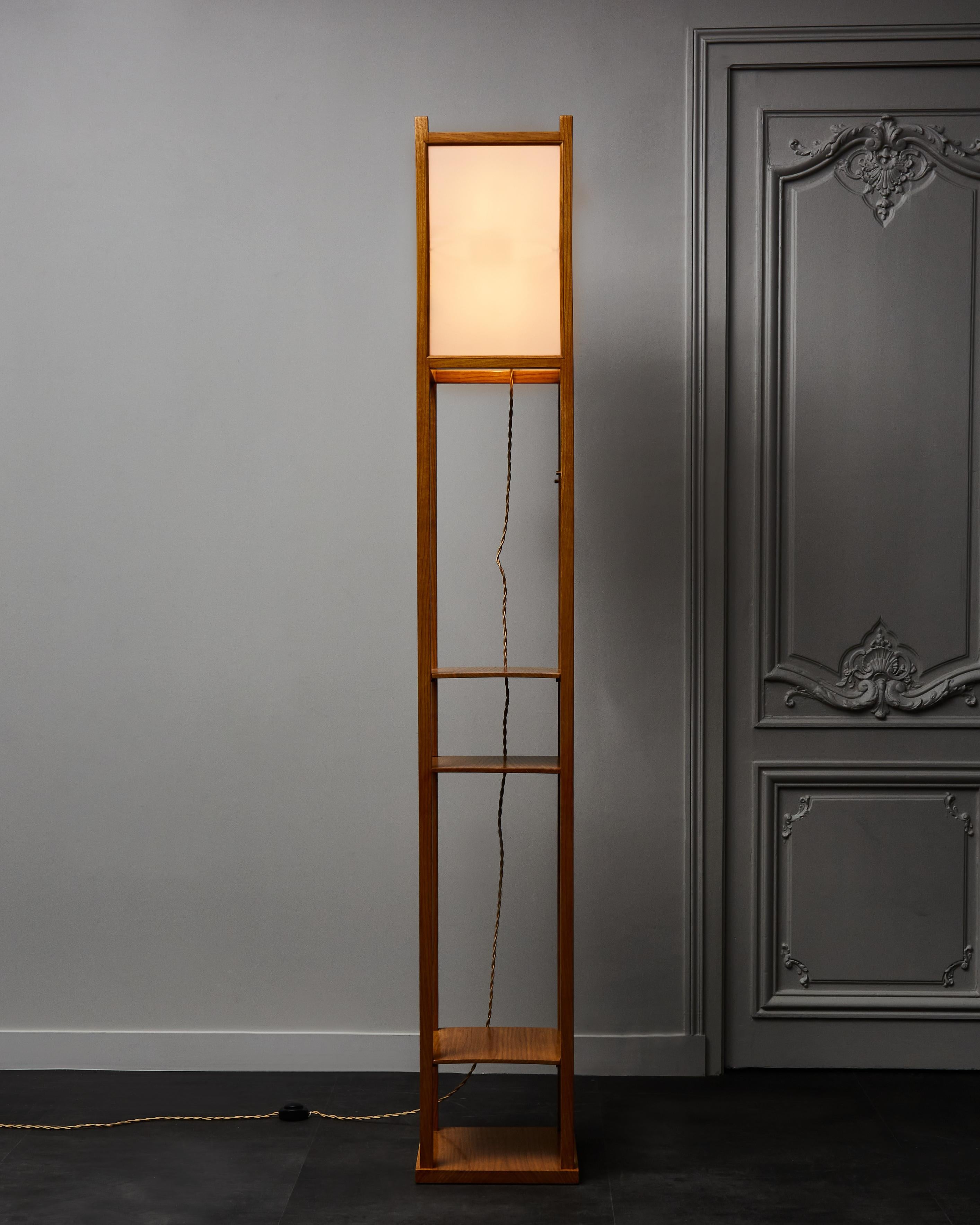 Impressively tall floor lamp made of a geometrical wood structure and light pink frosted glass panels (the color is barely noticeable when the floor lamp is on). It also comes with three shelves that you’re able to place at different locations on