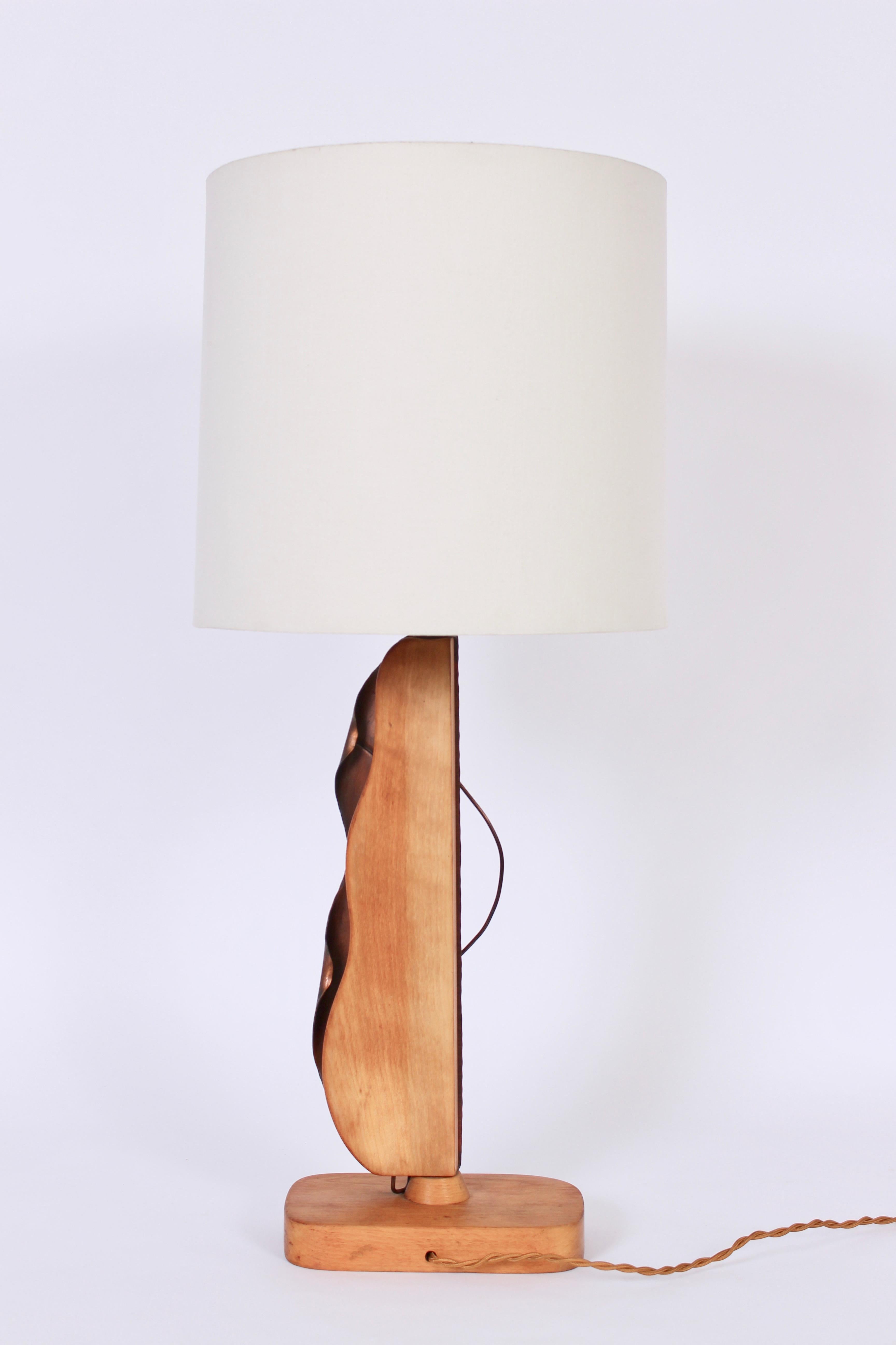 Larger American Mid Century handcrafted Yasha Heifetz copper and bleached mahogany table lamp. Featuring a hand sculpted abstract copper panel and mahogany body atop a rounded rectangular mahogany base. Shade shown for display only and not for sale