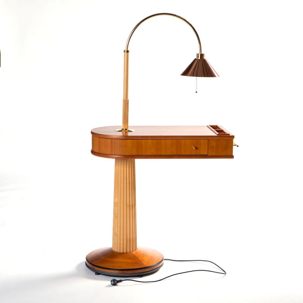 “Talo” lamp table, designed by Massimo Scolari for Giorgetti in 1989.

The tabletop is crafted from cherry wood and can be rotated 180°. The integrated drawer rotates 360°.
The lamp stem is made of wood and extends into an elegant arc of polished