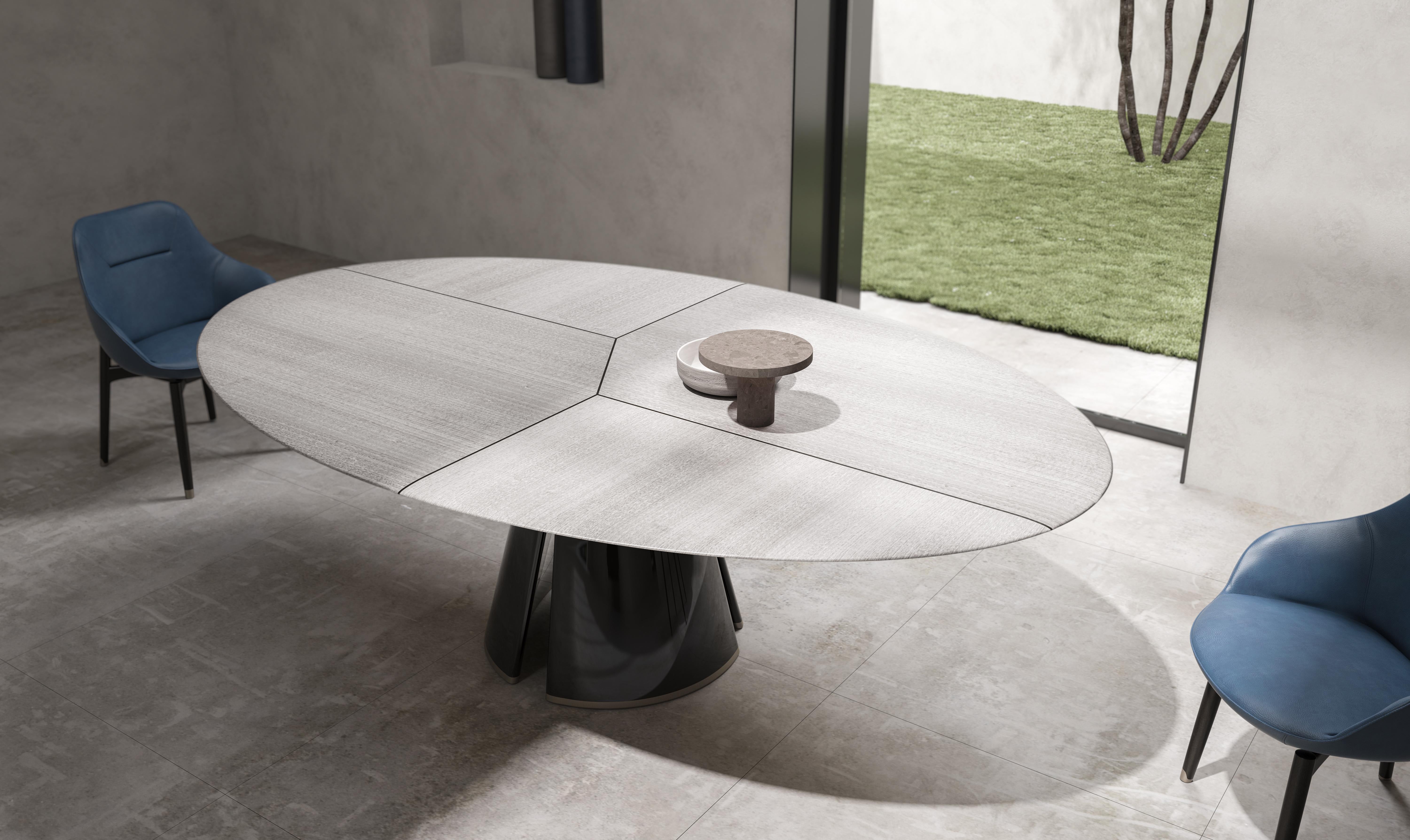 Il s'agit d'une élégante table de salle à manger de forme ovale avec un plateau en marbre saisissant. Le marbre présente une base blanche avec des veines audacieuses et irrégulières dans des tons de noir, de brun et d'or, créant un aspect luxueux et
