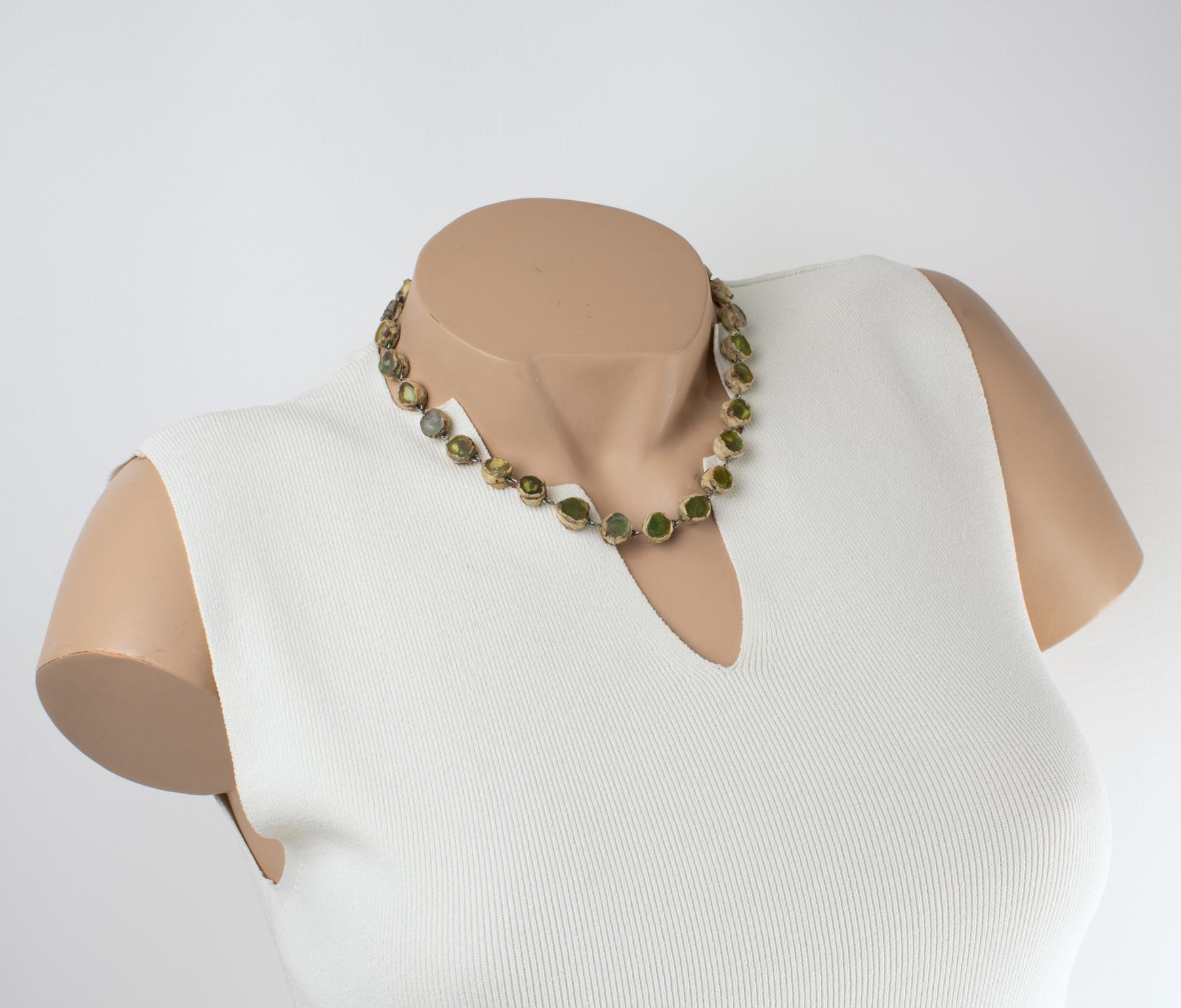 Spettacolare collana dalle delicate sfumature verdi, con frammenti a specchio, il tutto incastonato in Talosel color crema, resina francese, di Line Vautrin - realizzata in Francia nel 1960 circa.
Splendida collana di Line Vautrin Paris. La collana