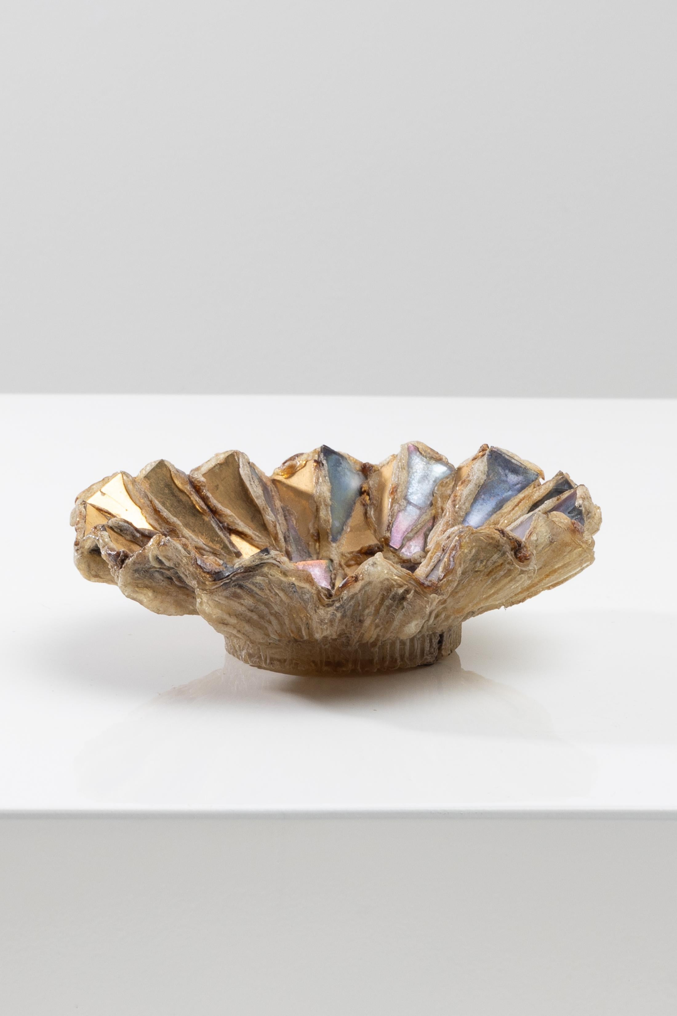 Talosel pocket emptier inlaid with mirror fragments by Line Vautrin (FR).
Pocket emptier or cup in Champagne-colored Talosel inlaid with fragments of golden, bronze and gray-violet mirrors.
The back of the object completely heat scarified.