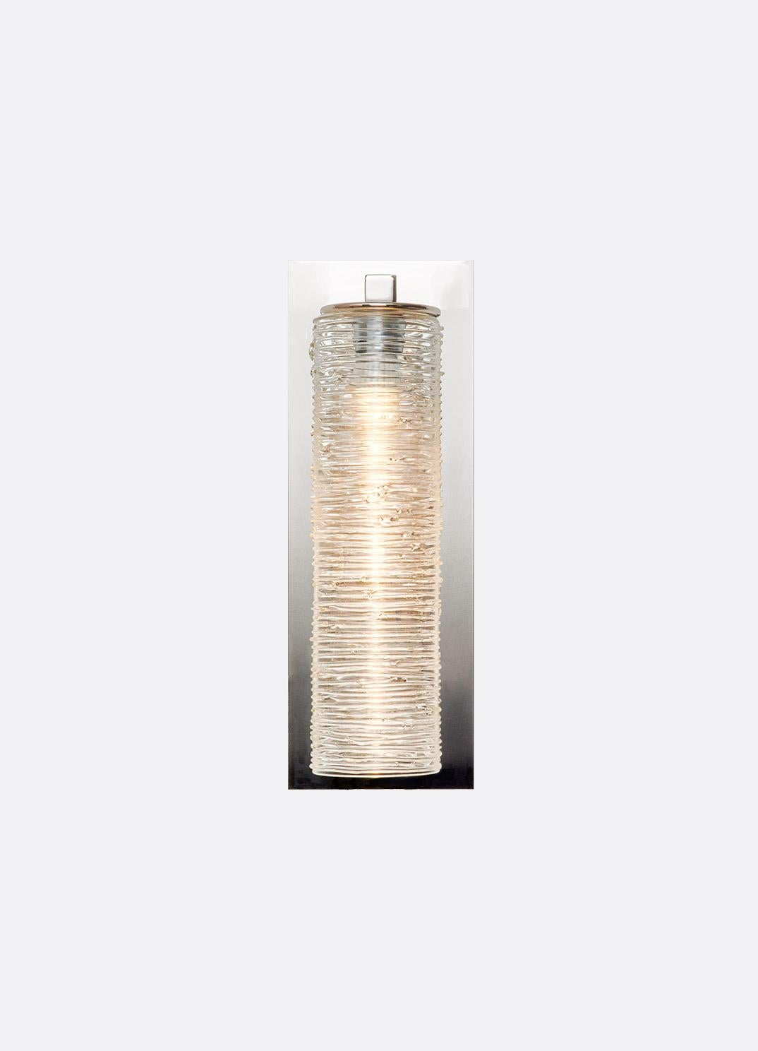 Rectangular wall sconce with arm with circular smooth edged disk holding the top of the glass pendant. Floating style back plate (6