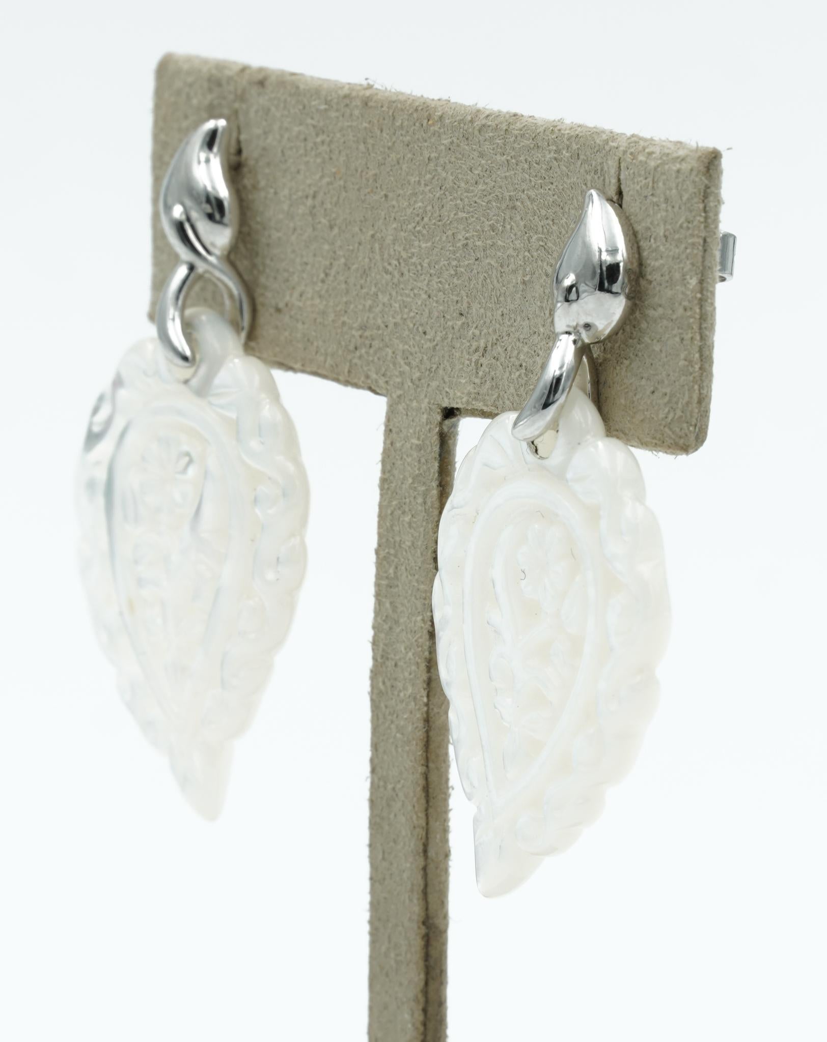 The INDIA Mother of Pearl earrings are a beautiful, casual classic. The dangling leaf is hand-carved on both sides and frames the face charmingly. Attached to an iconic drop-shaped stud in white gold, it is the perfect lightweight, everyday