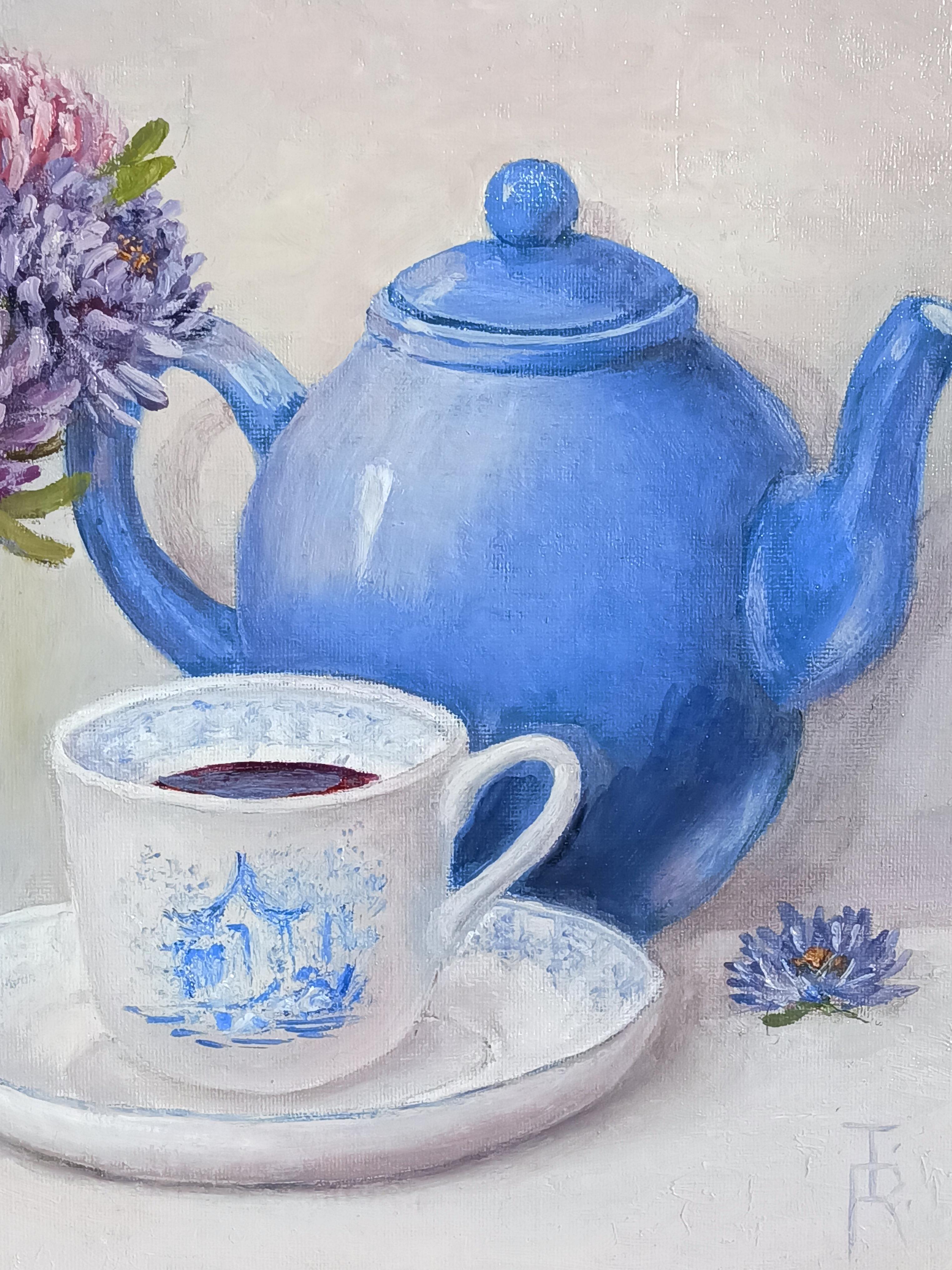 Die Wärme des Zuhauses versammelt sich auf einem stillen Tisch: eine blaue Teekanne, die darauf wartet, gefüllt zu werden, eine zarte Tasse, die verheißungsvoll leuchtet, Astern, frisch aus dem Garten, deren Farben zart wie Erinnerungen sind. Dies