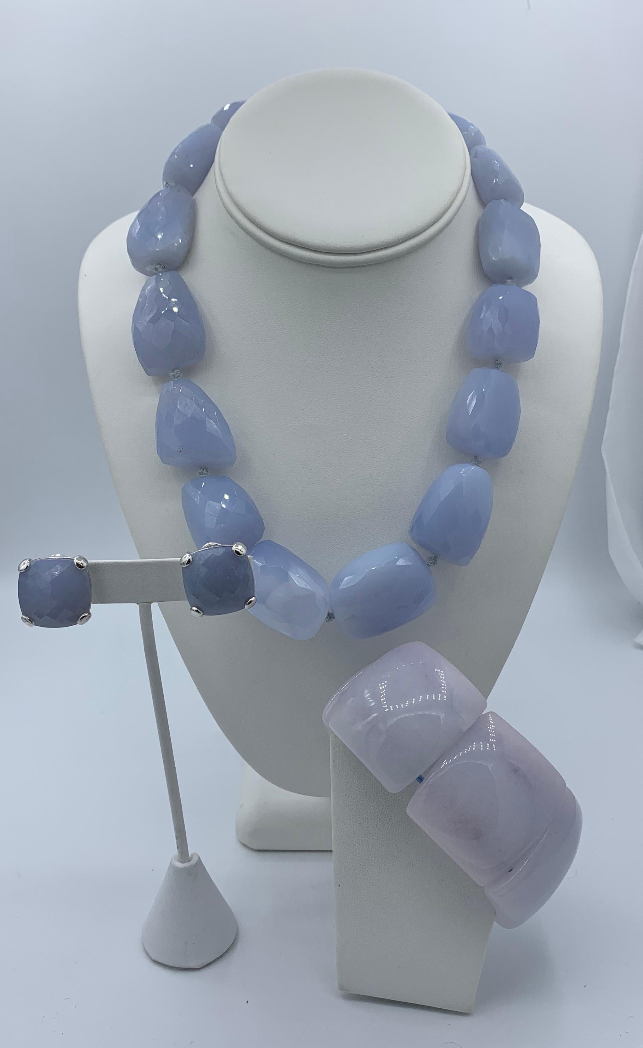 WE HAVE A STUNNING SET OF TAMBETTI WHITE GOLD AND BLUE CHALCEDONY JEWELRY FROM THE ESTATE OF LEGENDARY WRITER BARBARA TAYLOR BRADFORD, OBE (Order of the British Empire).  THE SET INCLUDES A NECKLACE AND EARRINGS WITH A PANEL LINK BRACELET.  
The