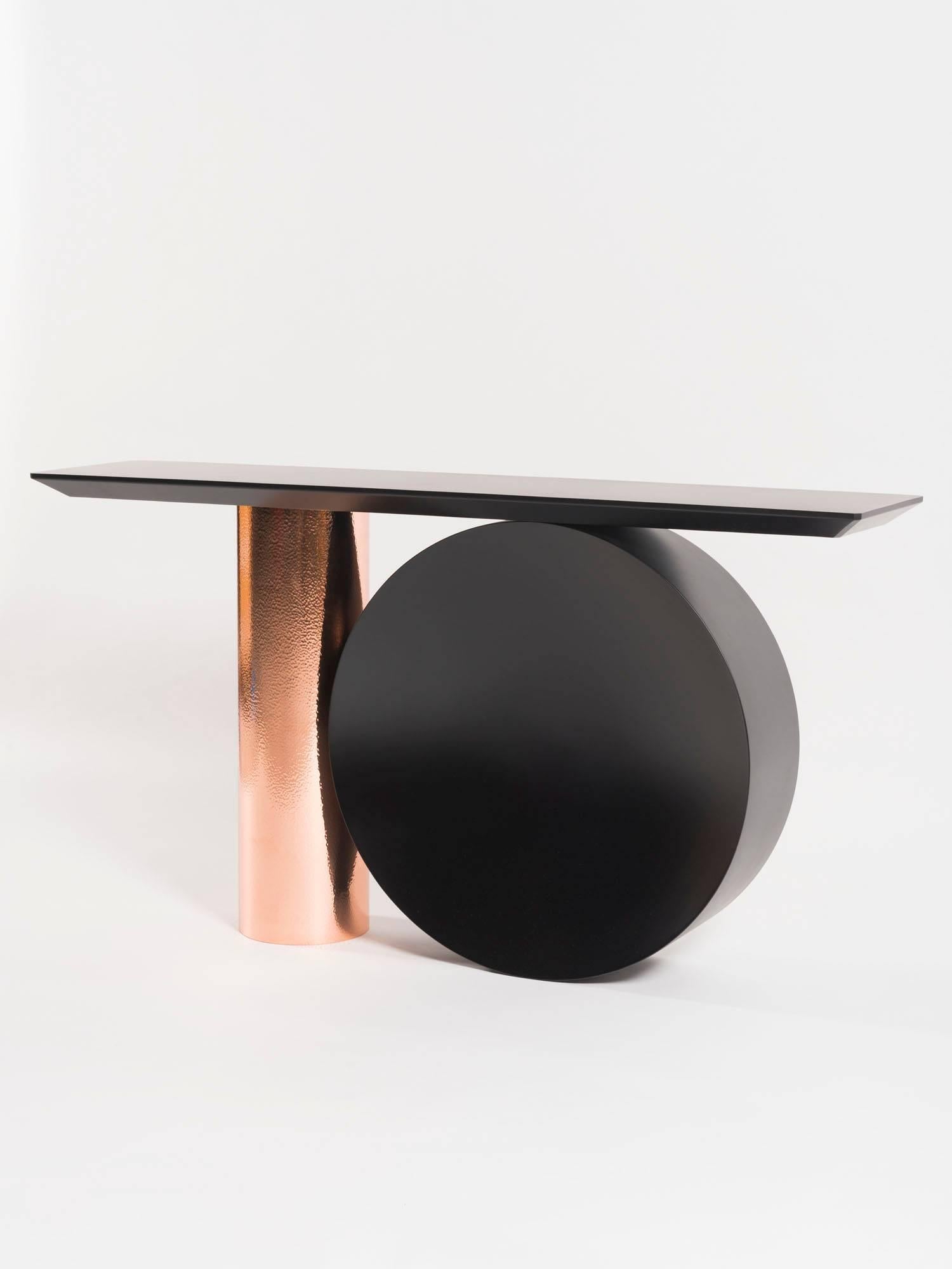 Tambour (drum in English) plays with the visual imbalance in its assembly which ensures its stability.

Materials:
Console base in hammered copper and black lacquered metal
Console top in black lacquered metal.