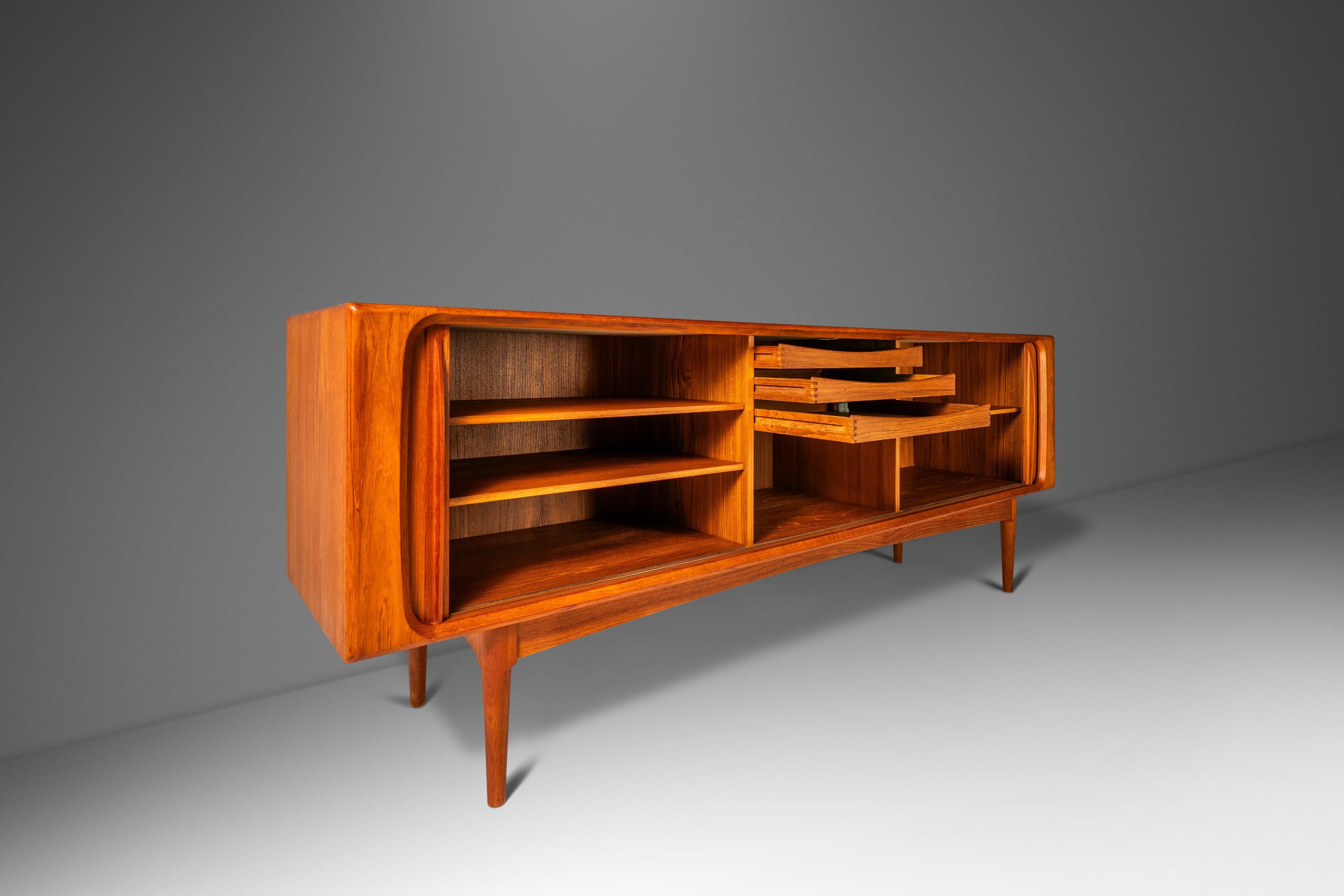 Audacious in scope, design and materials used this extraordinary Danish-made credenza is as functional as it is visually arresting. Constructed from a mix of solid and matchbook-veneered Burmese teak this striking sideboard is ideal for collectors