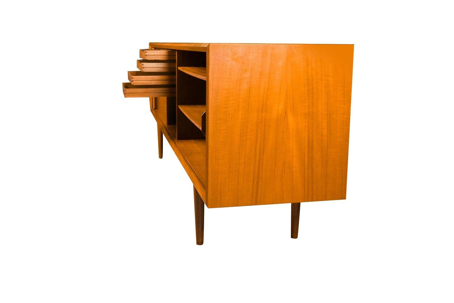Remarkable teakwood credenza designed by Famous designer Svend Larsen for Faarup Mobelfabrik in Denmark. This piece is long, low, and just stunning!!! Notice the width it is 10? longer than most. High quality Danish Modern piece, perfect for storing