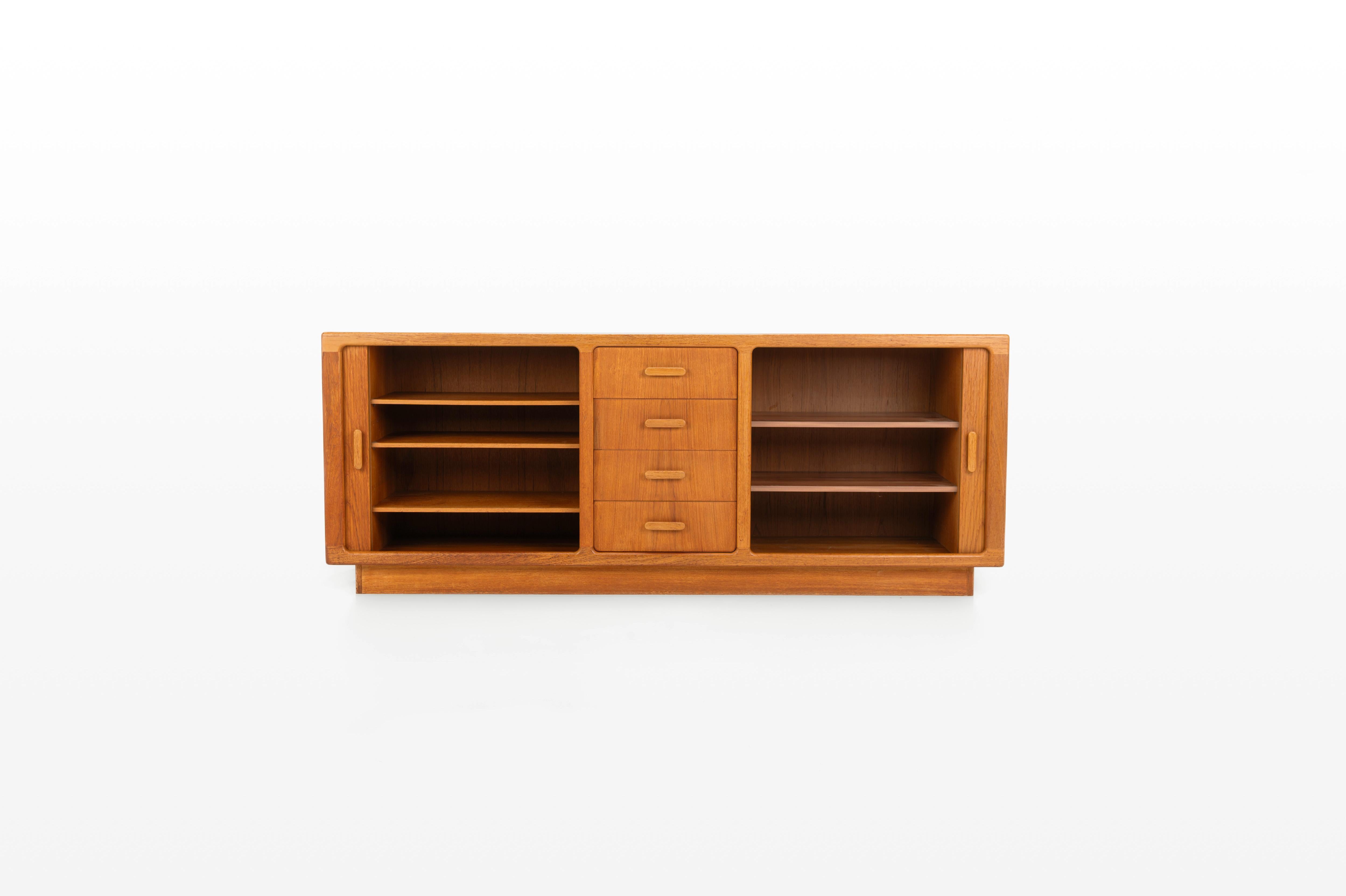 Danish vintage sideboard designed in the 1960s in Denmark by CFC Silkeborg Denmark. Teak version with tambour doors, five shelves and four drawers. The sideboard is in excellent condition and is marked by the producer.

Dimensions:
W: 200 cm
D: 46