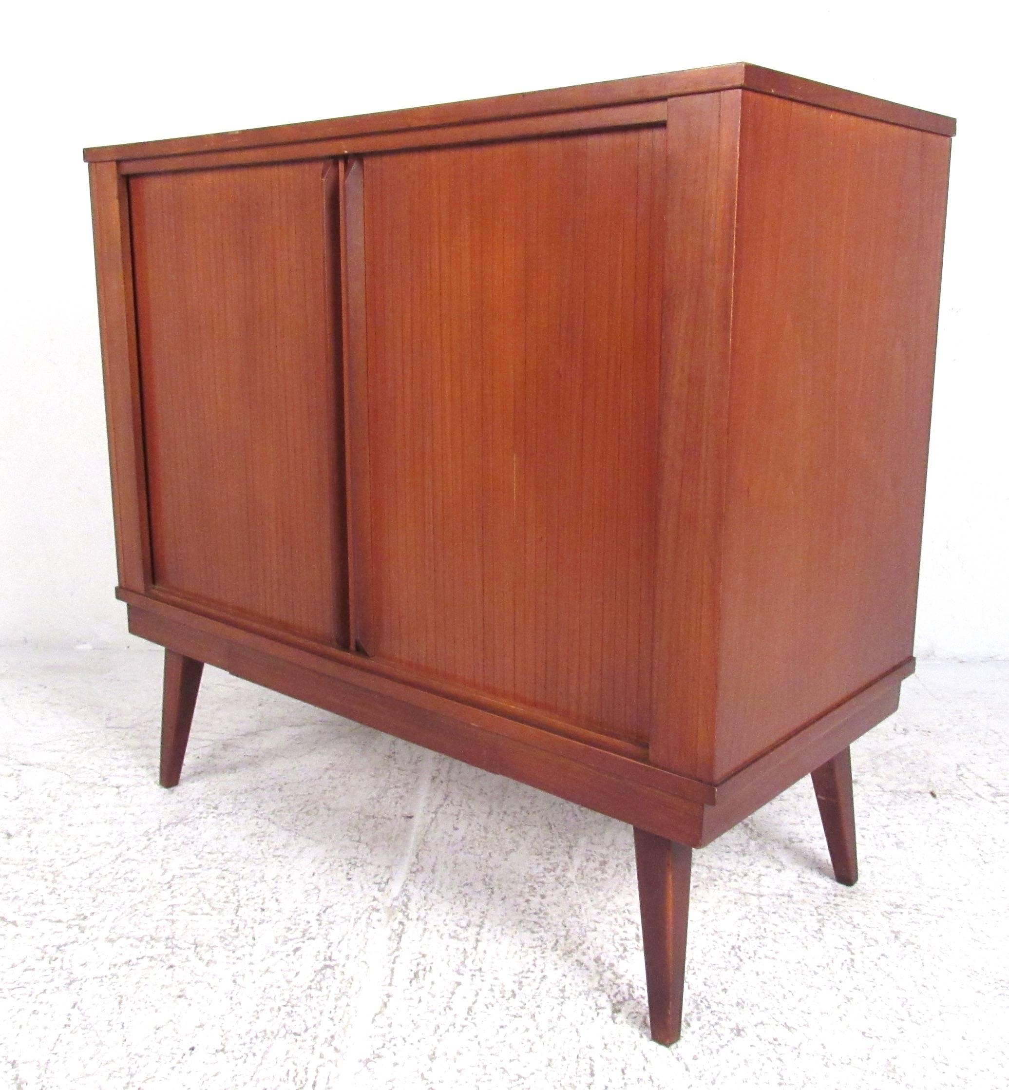 Nicely proportioned double tambour walnut cabinet with tapered legs. Ideal for entertainment centre/flat screen. Please confirm item location (NY or NJ) with dealer.