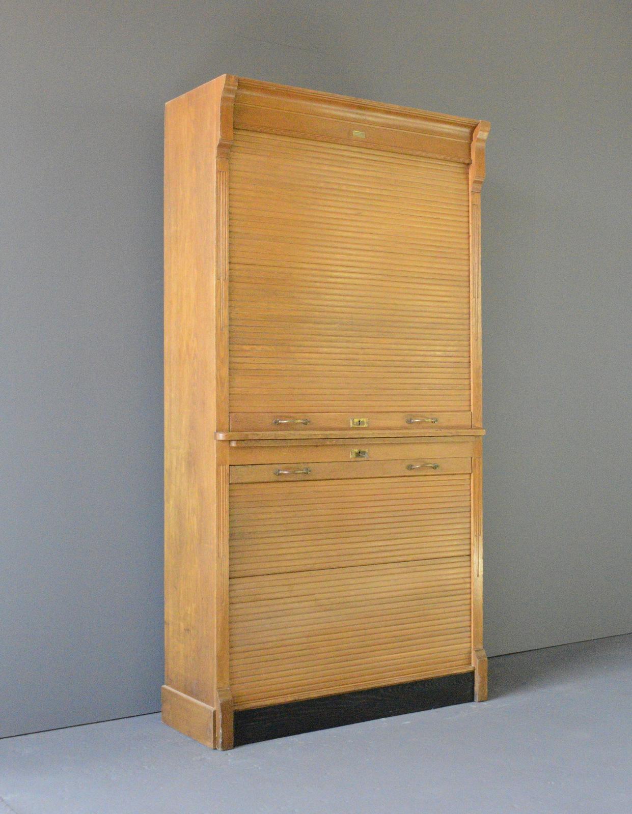 Tambour Fronted Cabinet circa 1920s

- 2 Tambour shutters
- Original solid Brass handles
- Pine shelves with Oak frame
- Made by Gebruder Scholl, Zurich
- Swiss~ 1920s
- 93cm wide x 43cm deep x 213cm tall

Condition Report

Both tambours