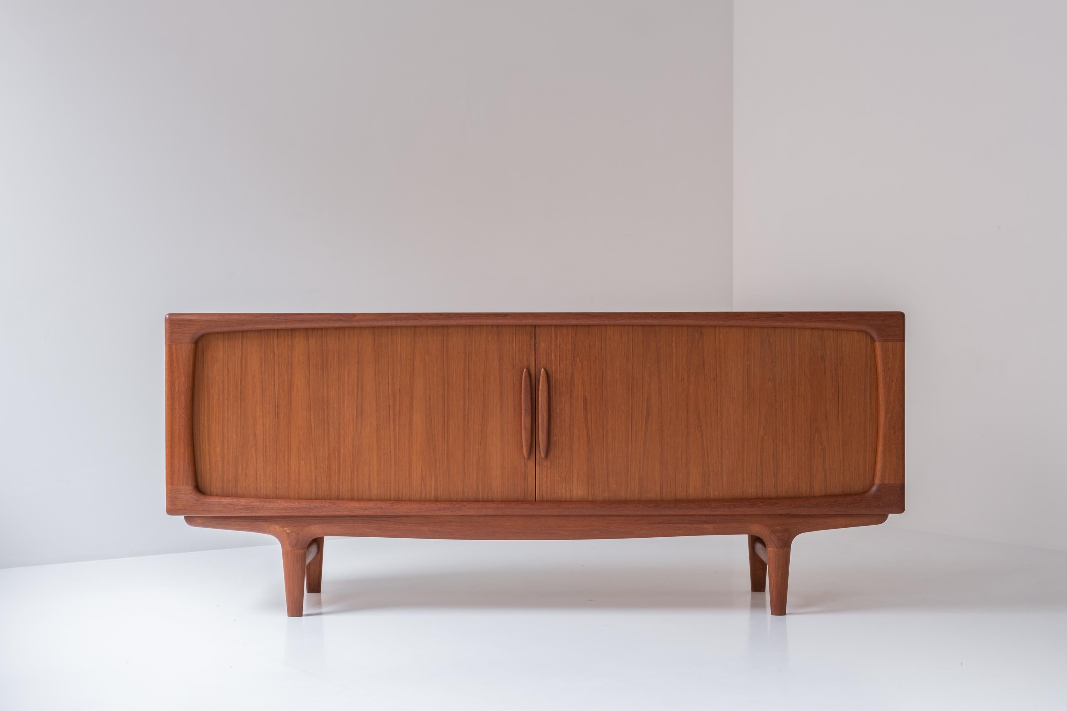 Elegant sideboard by Johannes Andersen for Falster, Denmark 1960s. This sideboard is made out of teak and features tambour sideboards covering a series of adjustable shelves and drawers inside. Very well presented condition. Labeled inside.