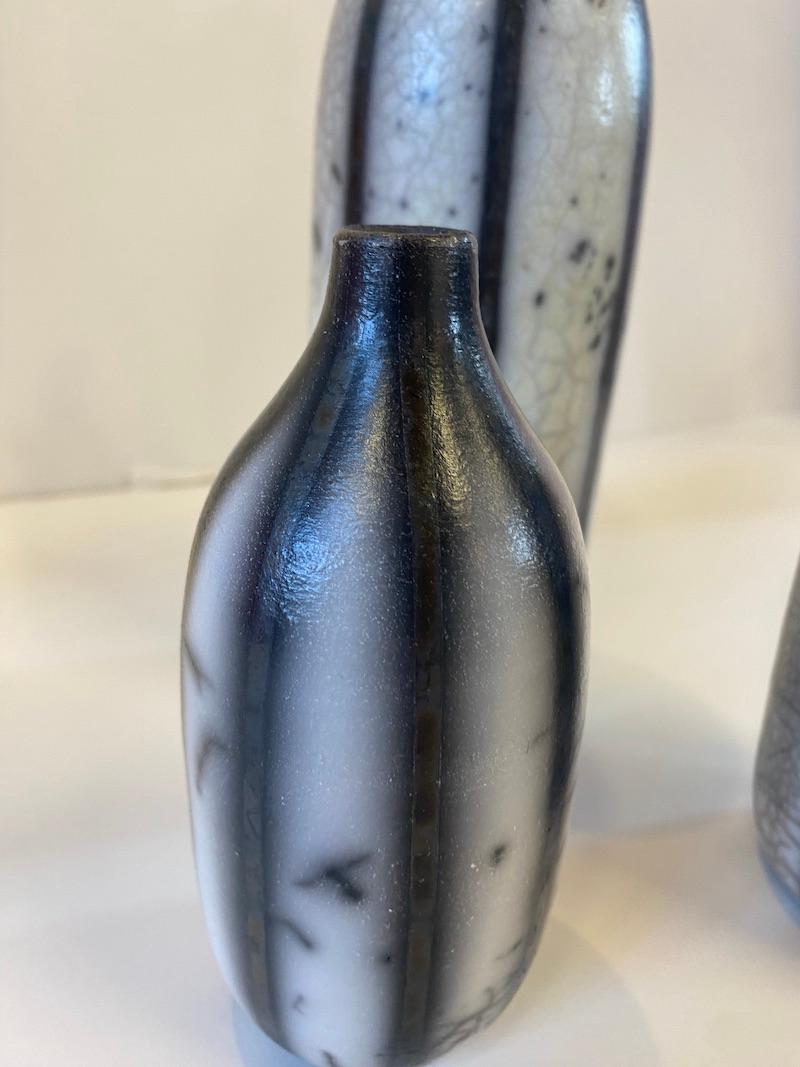 3 botellas cocidas en Raku en blanco y negro con un dibujo de rayas. El juego consta de botellas pequeñas, medianas y grandes.

INFORMACIÓN ADICIONAL:
Cerámica sobre piedra
30 cm de alto x 10 cm de ancho x 10 cm de profundidad (11,81 x 3,94 x 3,94