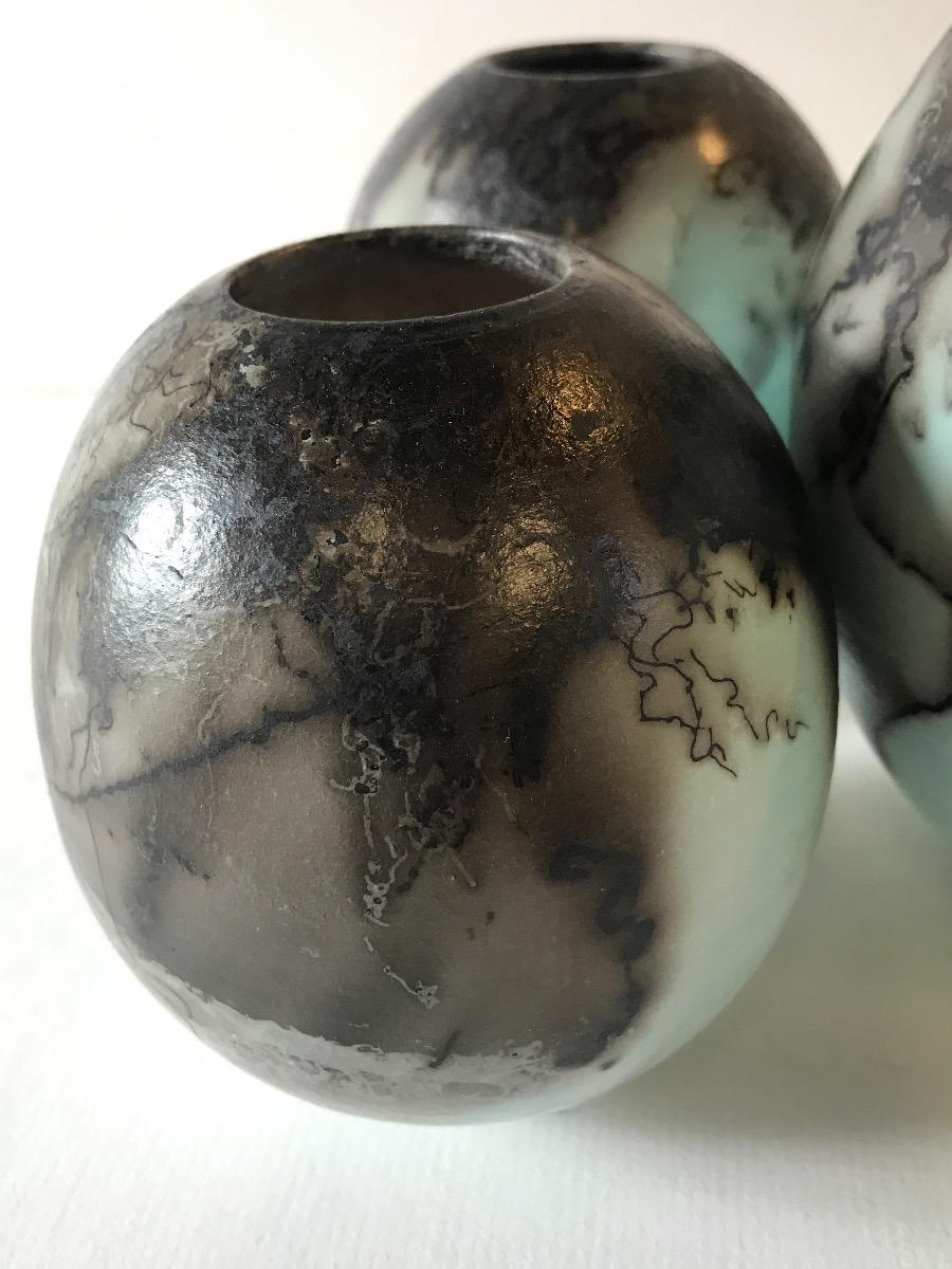 Three Duck Egg Blue Horse Hair Raku Fired Ball Vases by Tamsin Levene.

Three Duck Egg blue horse hair raku fired ball vases. Set contains small vase, medium vase, and large vase. 

ADDITIONAL INFORMATION:

Ceramic on Stone
16 H x 15 W x 15 D cm