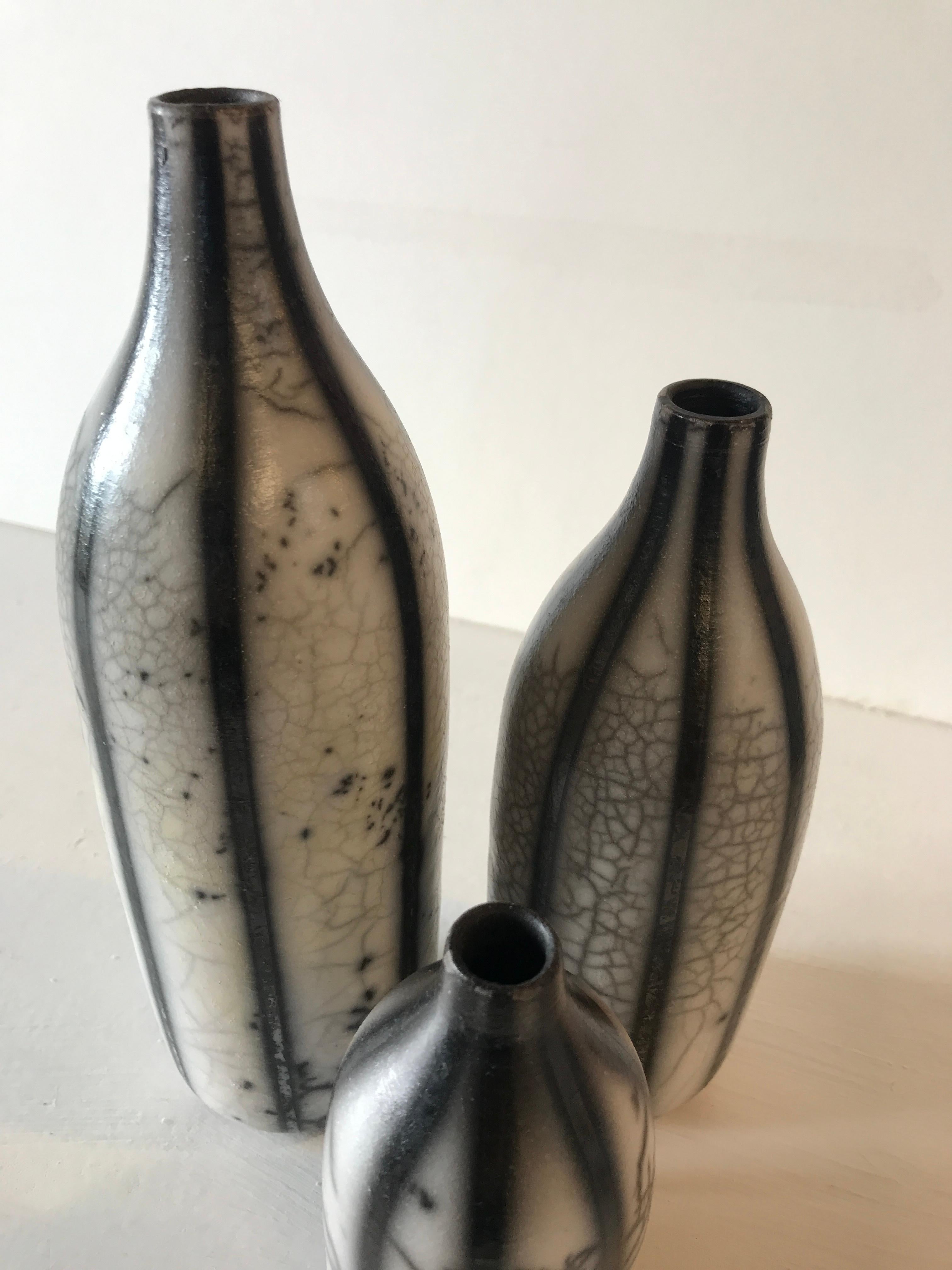 Three Raku Striped Bottles by Tamsin Levene.

Three raku striped bottles. Set contains small bottle, medium bottle, and large bottle. 

ADDITIONAL INFORMATION:

Ceramic on Stone
22.5 H x 9 W cm (8.86 x 3.54 in)
Sold as a set of three

SIZES:
Large: