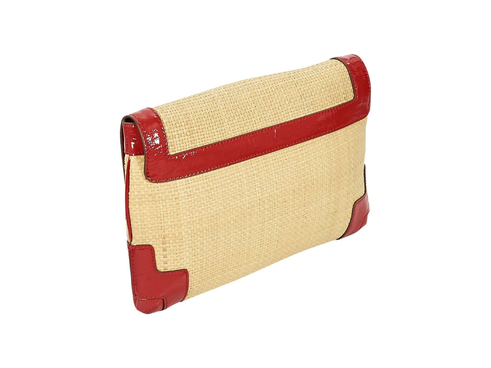 Product details:  Tan straw clutch by Anya Hindmarch.  Trimmed with red patent leather.  Front flap with concealed magnetic closure.  Lined interior with inner zip and slide pockets, pen slot and key fob.  Goldtone hardware.  Dust bag included. 