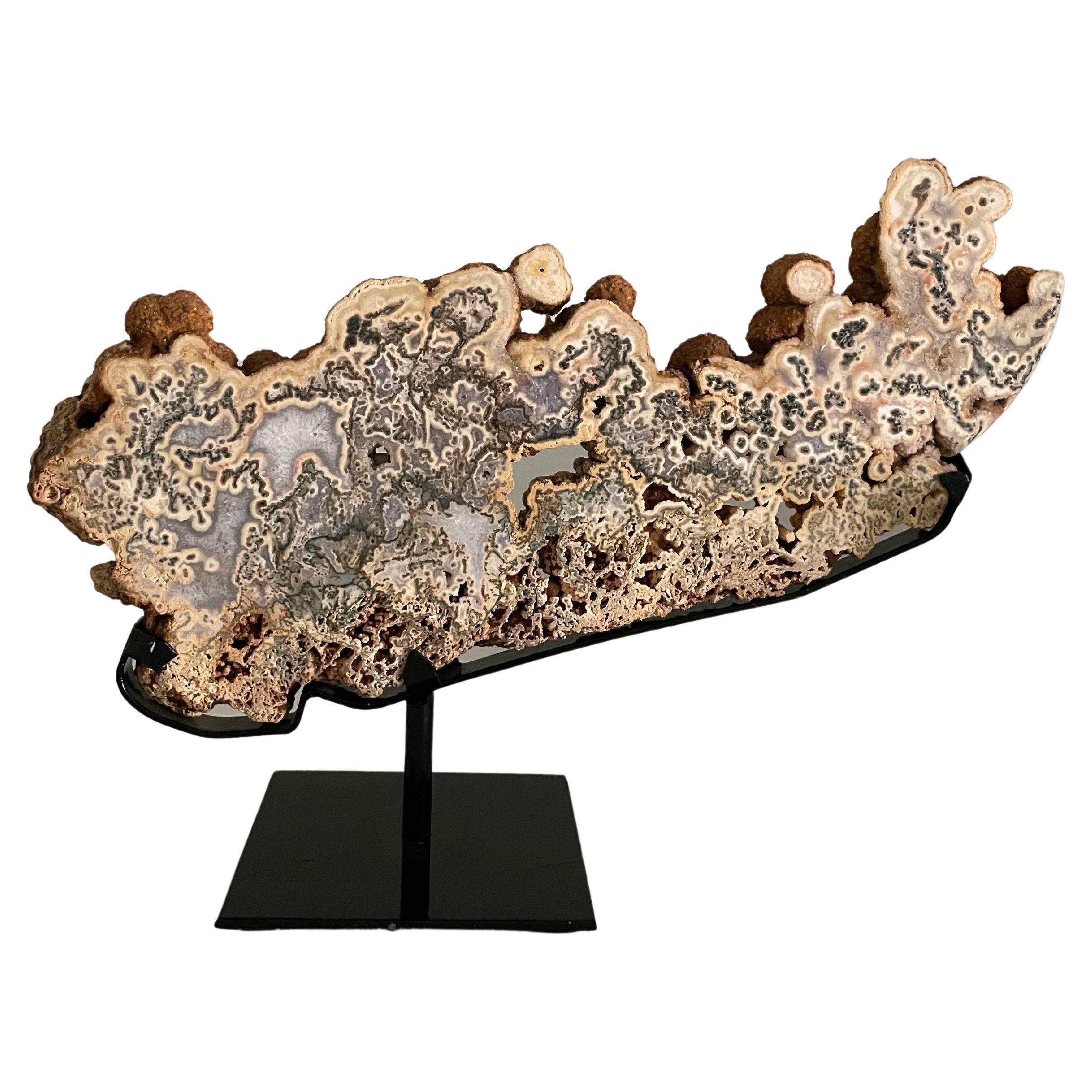 Tan with shades of grey Brazilian tree agate sculpture mounted on a metal stand.
Organic horizontal shape.
Beautiful natural coloring.
From a large collection, many different sizes are available.
Stand 6