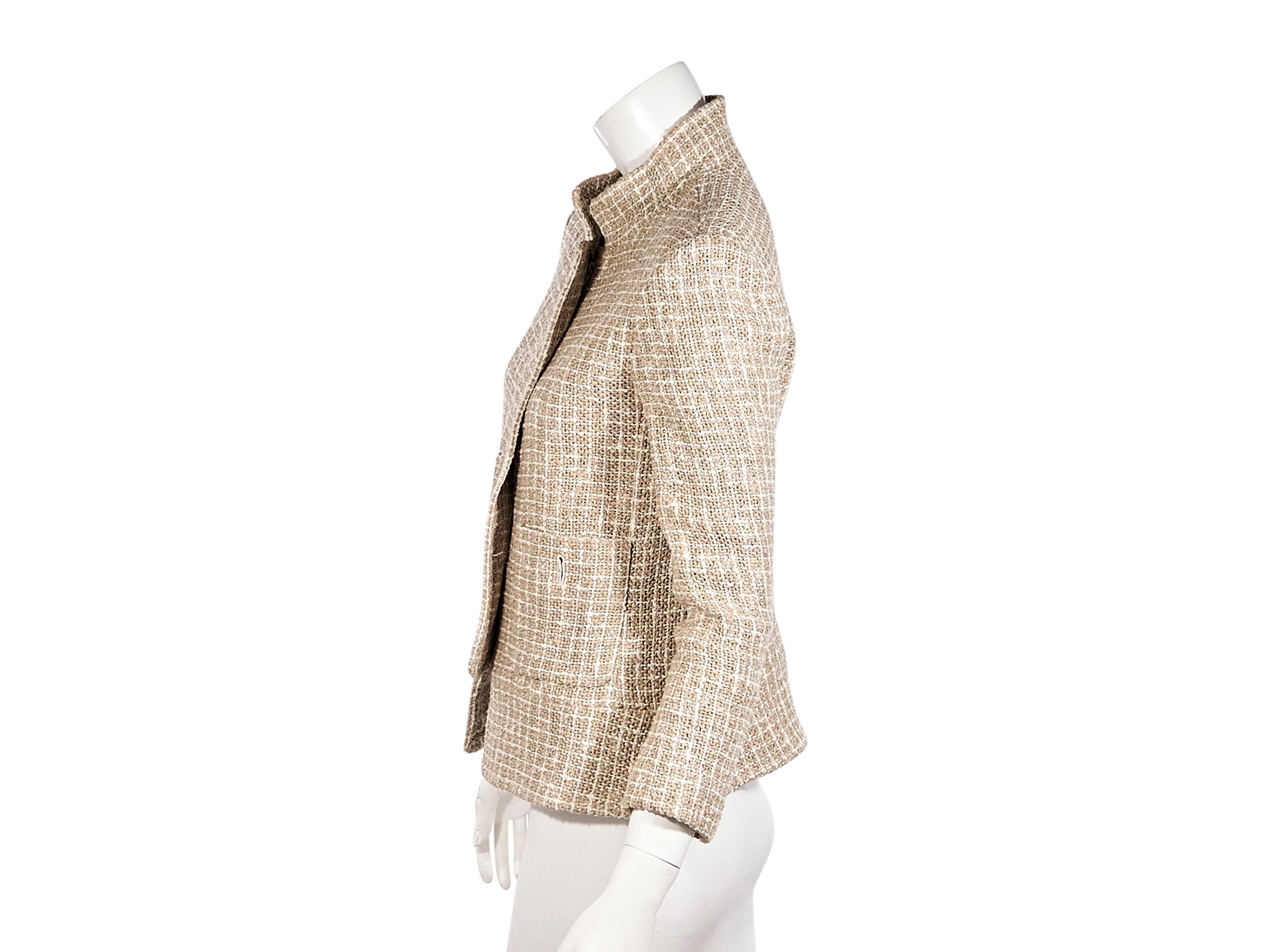 Product details:  Tan and white tweed jacket by Chanel. High collar.  Cropped sleeves. Concealed zip-front closure.  Dual pockets at front. Silver-tone hardware. Wear layered over a white-T-shirt and wide-leg jeans. 31
