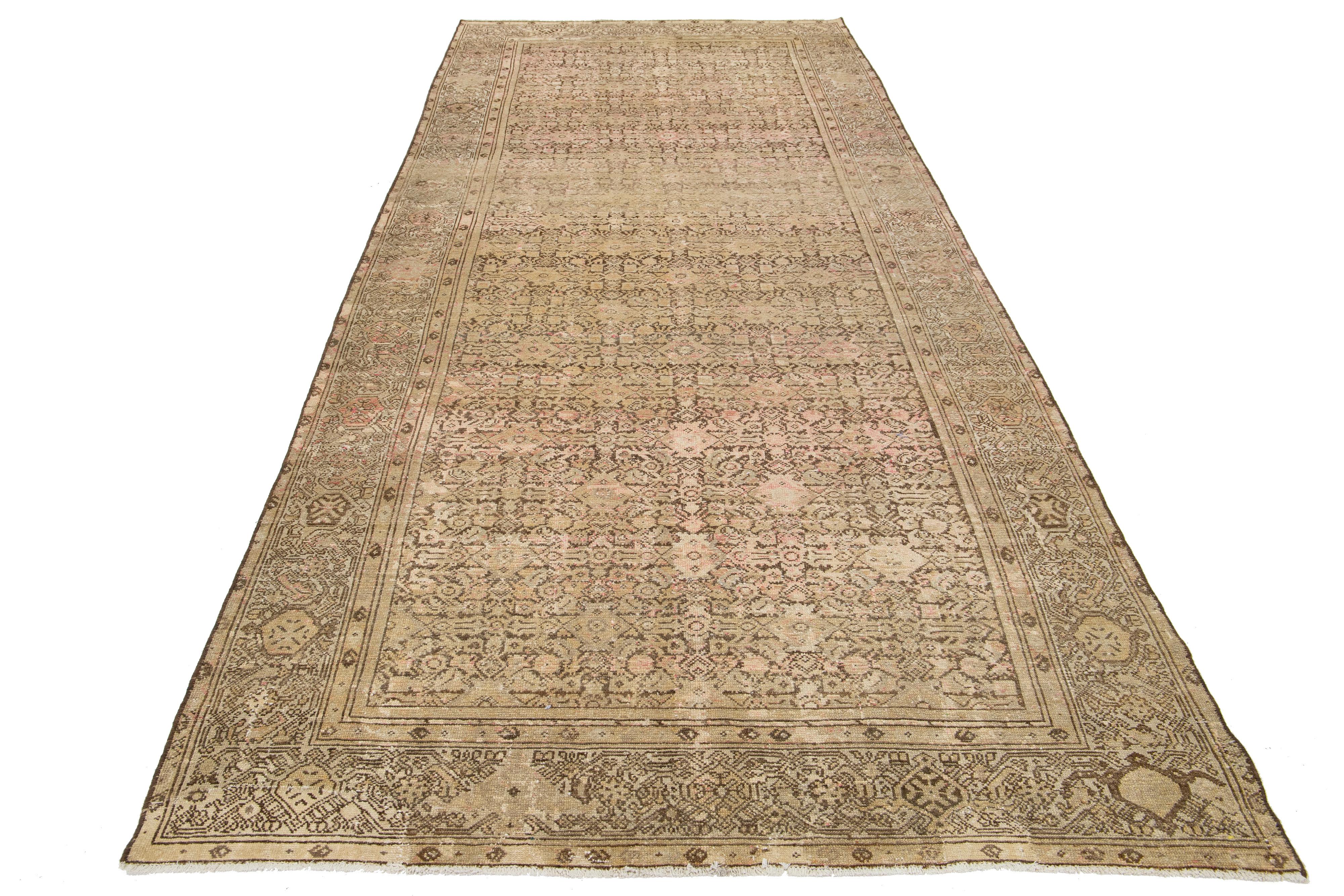 This is a handmade Persian Malayer wool rug from the 20th century. It features a beige-tan field with brown, pink, and gray accents throughout the design.

This rug measures 5'8