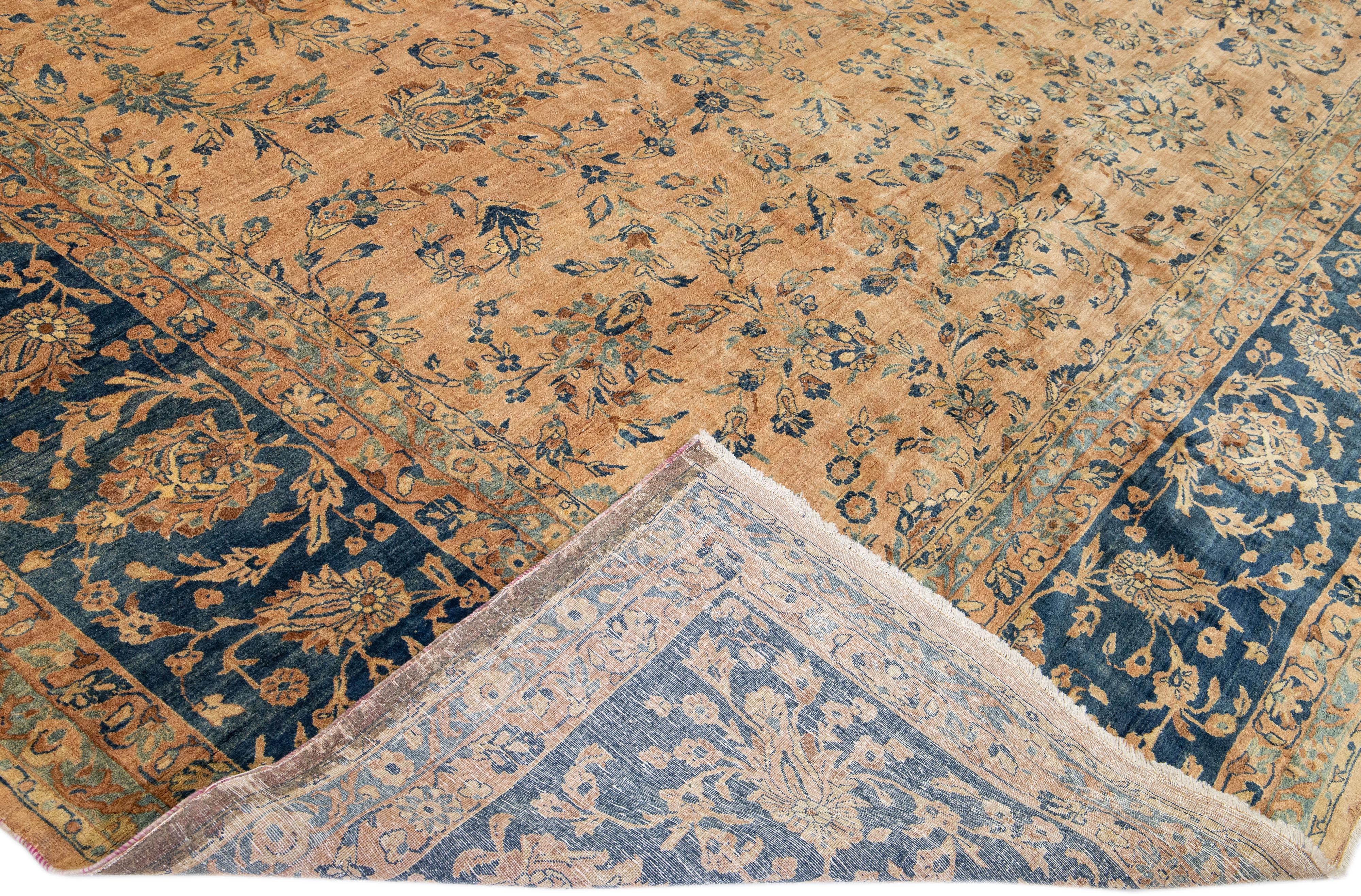 Beautiful antique Tabriz hand-knotted wool rug with a tan field. This Persian rug has a navy blue-designed frame with brown accents on a Classic floral design.

This rug measure: 15'2