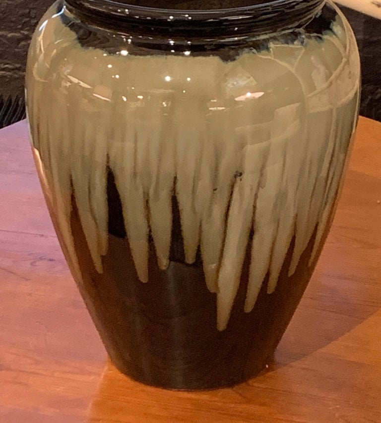 Contemporary Chinese ceramic vase with decorative drip glaze.
Vertical drip pattern on dark brown iridescent glazed bottom.
Hints of deep blue are exposed beneath the dark brown lip.
Two are available and sold individually.

 