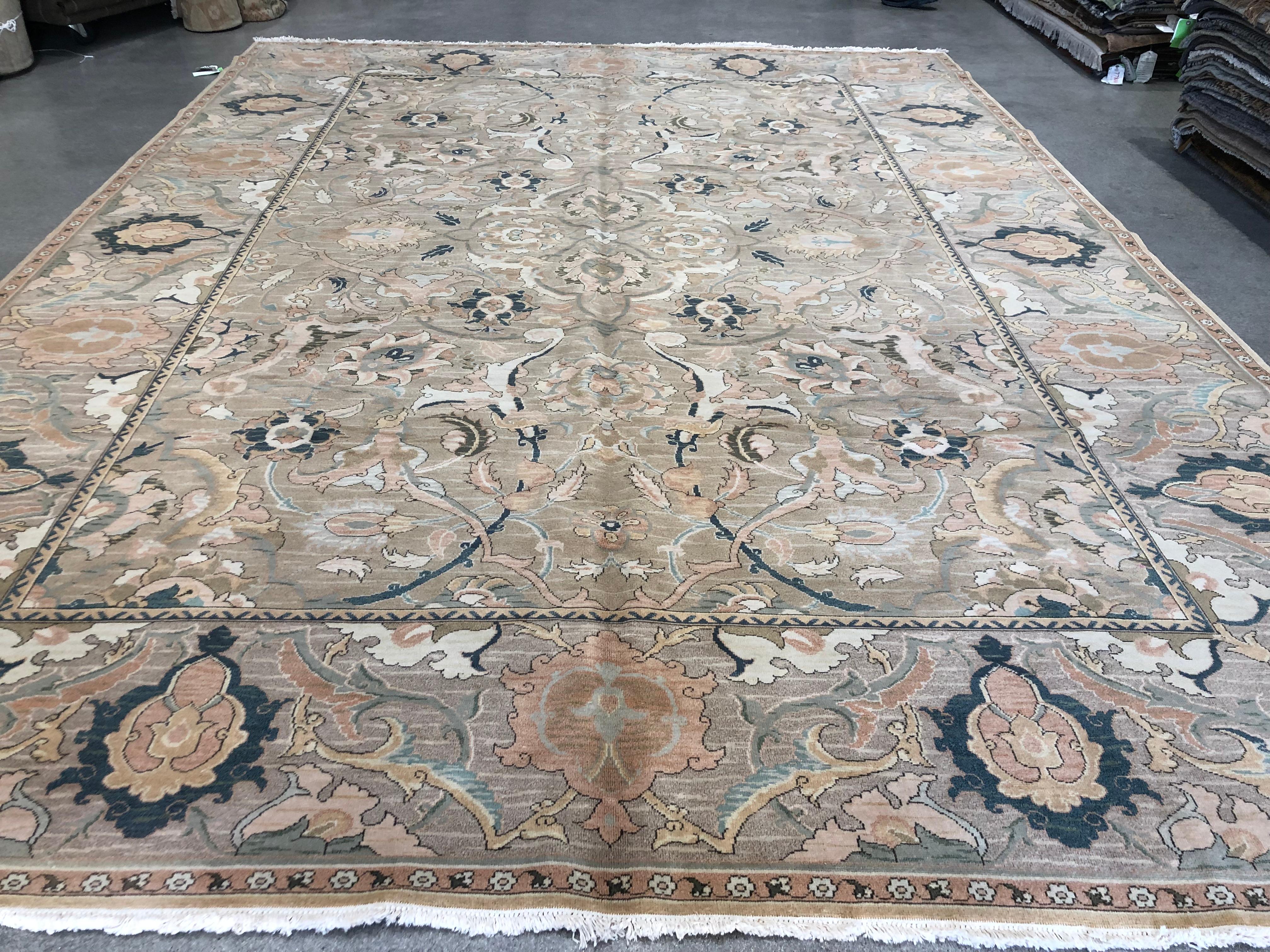 A rug that stands out for its unique design and color combination. A ribbon 'frame' creates a rug-within-a-rug look of sweeping floral designs that combines peach, cream, black and teal against a tan background. Hand knotted wool.