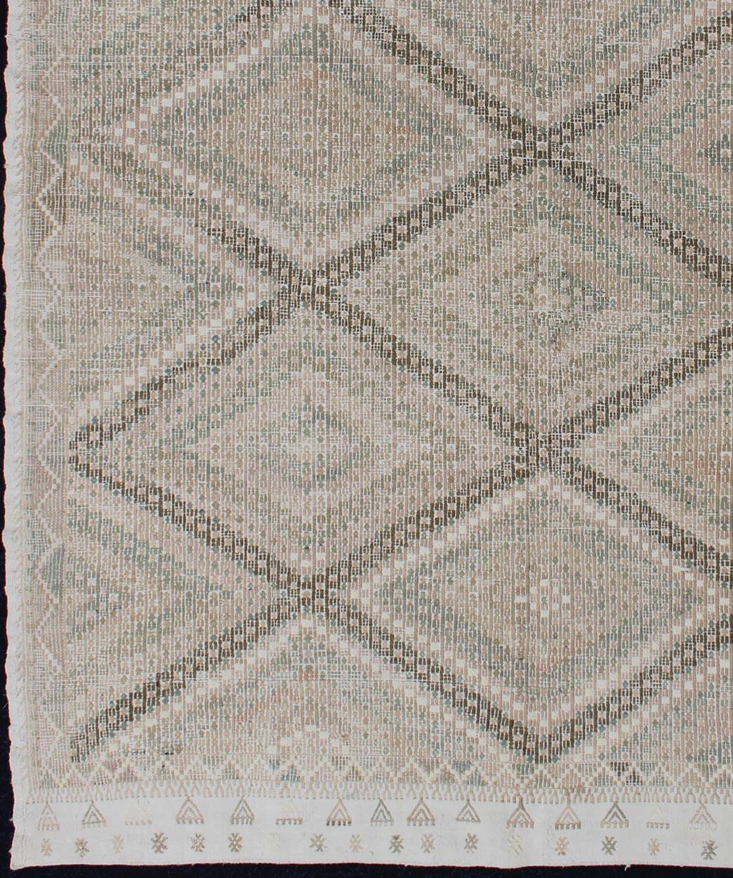 Tapis Kilim vintage brodé de Turquie dans les tons de tan, Taupe, marron clair, vert et jaune clair avec motif géométrique, tapis EN-179003, pays d'origine / type : Turquie / Kilim, circa 1950.

Mesures : 6'9 x 9'6.

Ce Kilim géométrique de Turquie