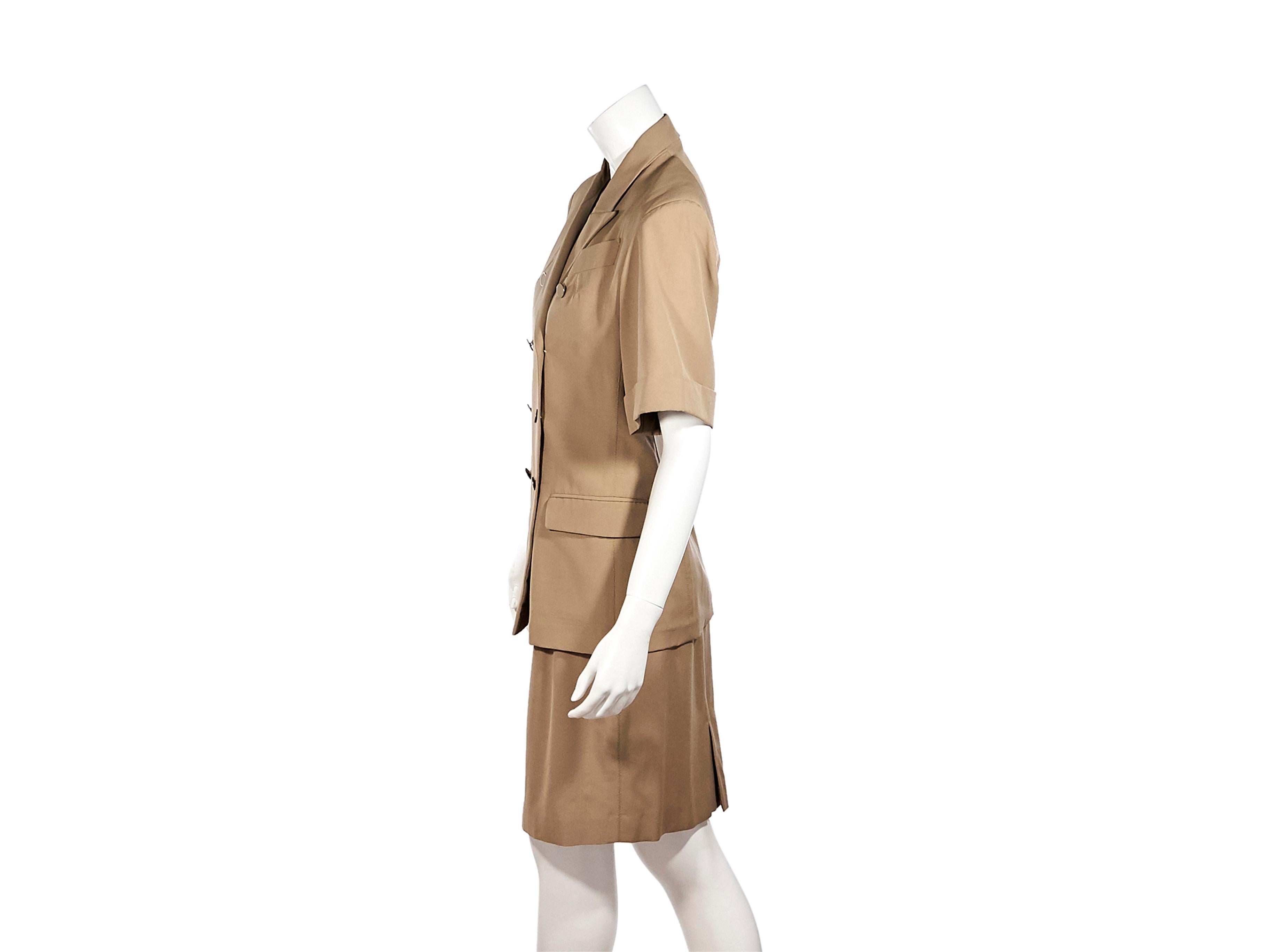 Product details:  Tan skirt suit set by Jean Paul Gaultier Femme.  Peak lapel.  Elbow-length sleeves.  Double-breasted button-front closure.  Chest besom pocket.  Waist flap pockets.  Matching pencil skirt.  Grosgrain banded waist.  Center back hem