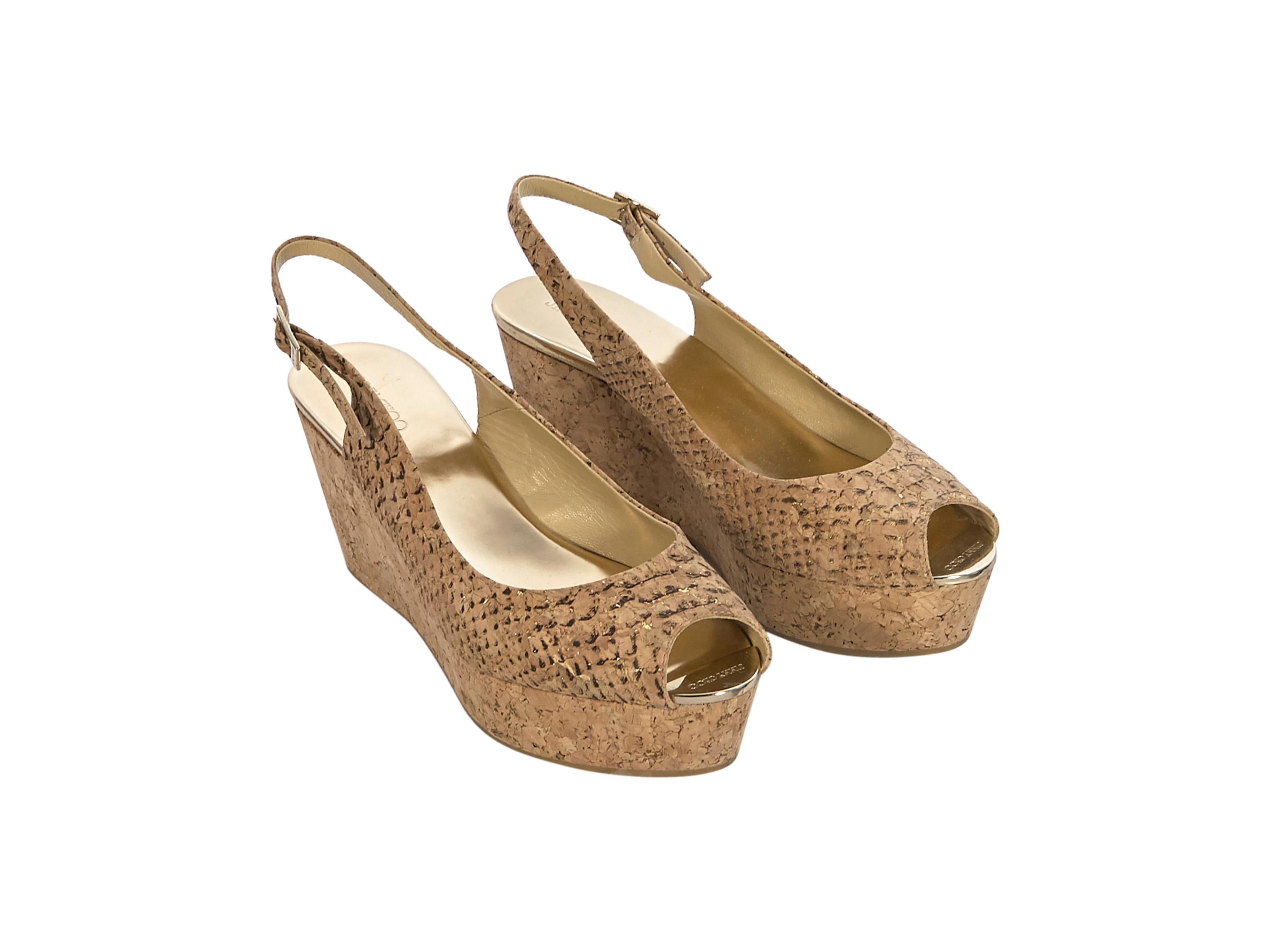 Product details:  Tan cork wedges by Jimmy Choo. Peep-toe. Cork heel. Adjustable ankle strap closure. Gold-tone hardware. Style yours with a midi linen dress. 3