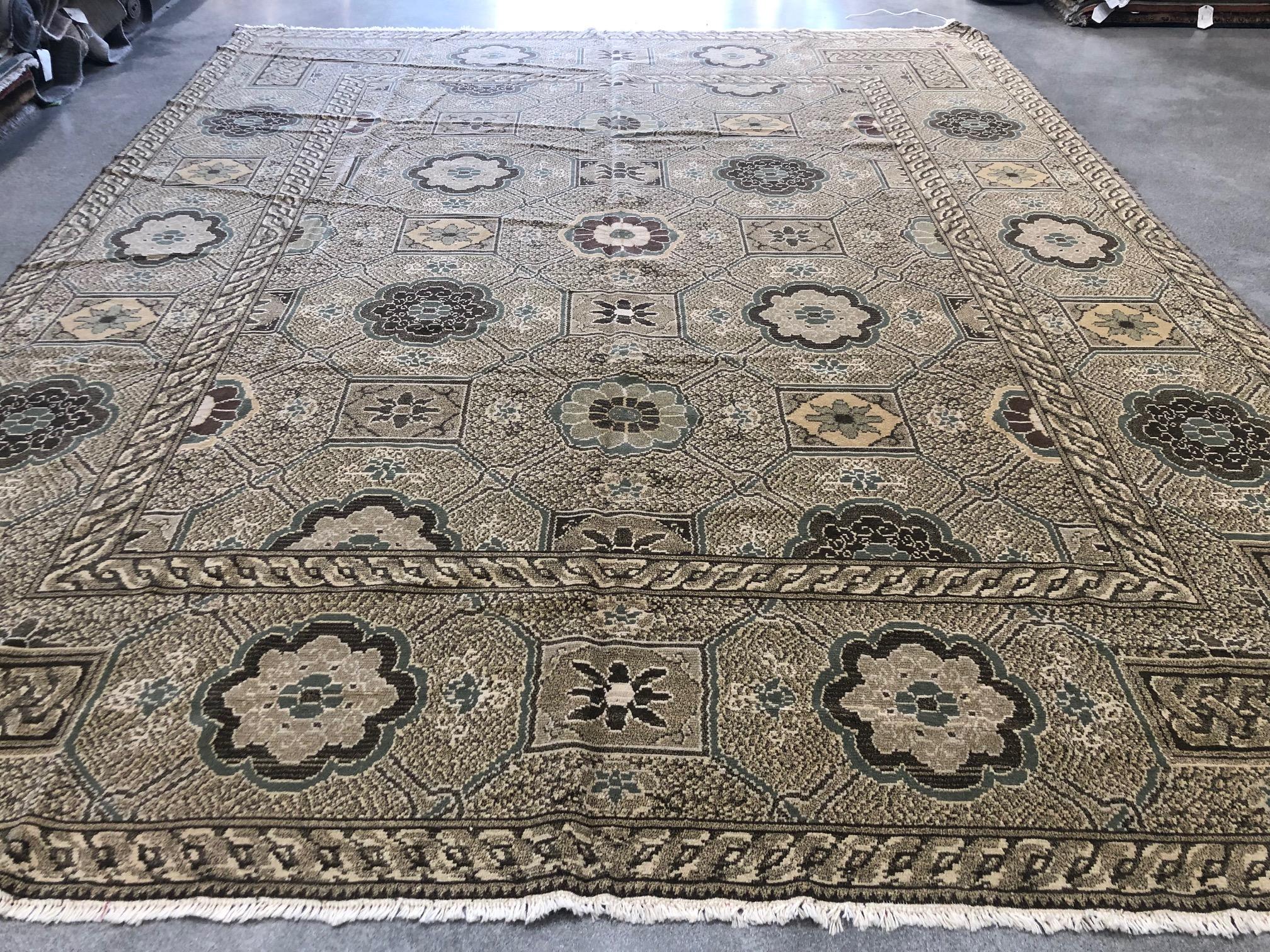 An eclectic mix of stylized flowers and geometric shapes characterizes this traditional Khotan style tan rug. Braided frames create a unique rug-within-a-rug look. Hand knotted wool.