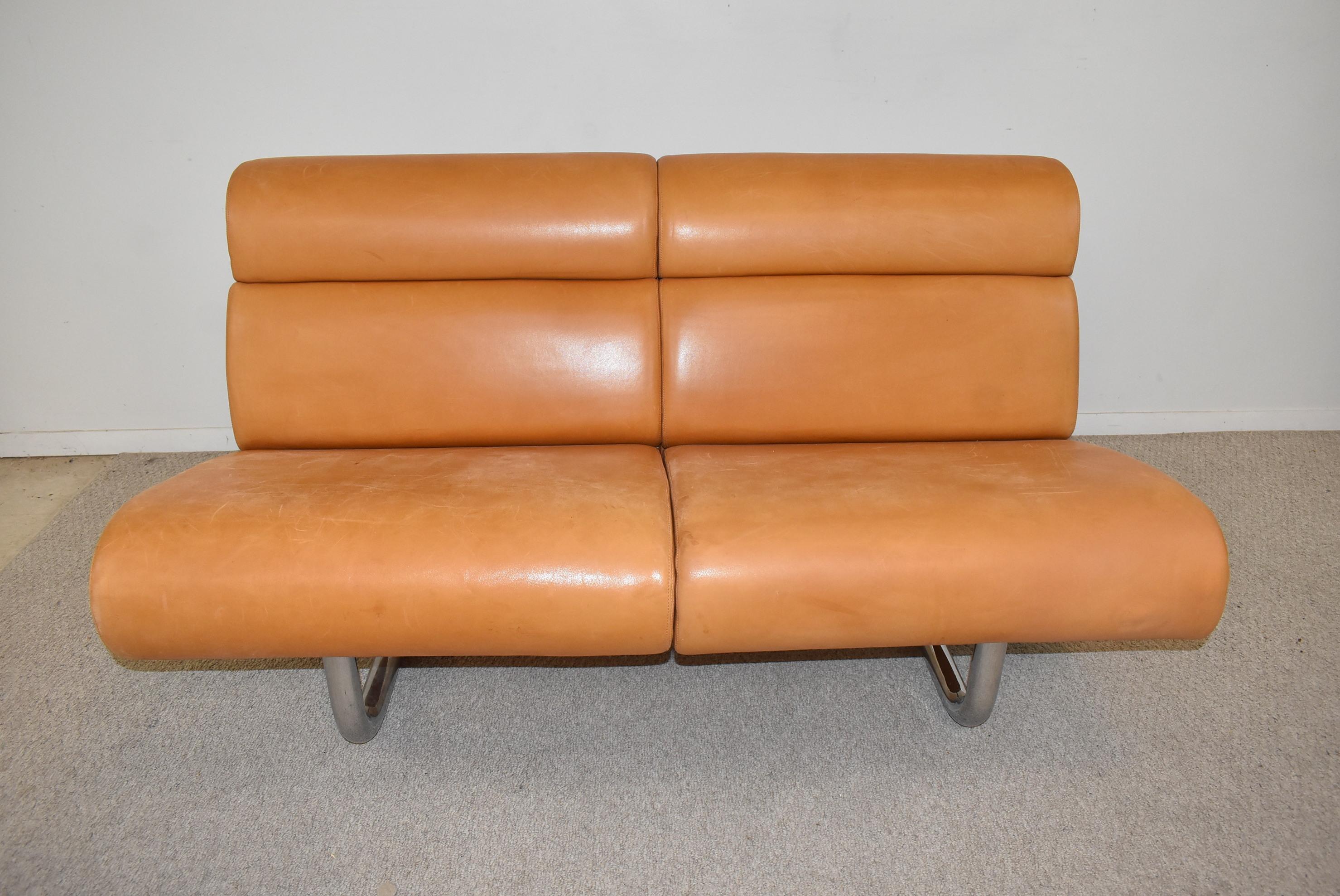 This 1970 sofa designed by Richard Schultz for Knoll features a leather cushioned front and back, and was created with modular sections that hang from a steel tubular frame. There has been minor leather repair to the right front edge. 56