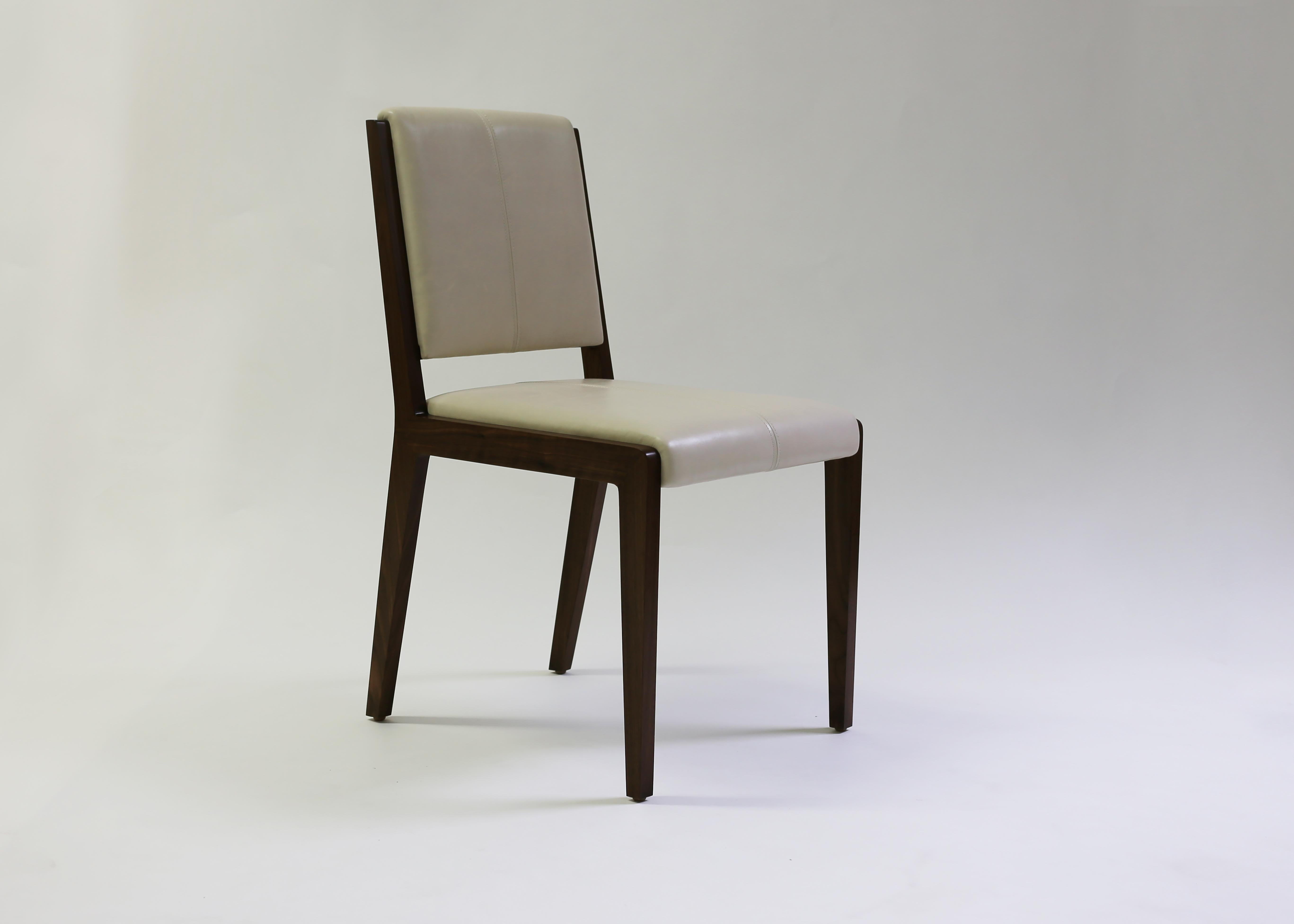 La chaise Emile de LF upholstery, présentée en cuir beige avec des détails artisanaux en points sellier sur l'intérieur du dossier et de l'assise, donne un aspect sophistiqué à une chaise de style classique. Peut être utilisé à la fois comme chaise