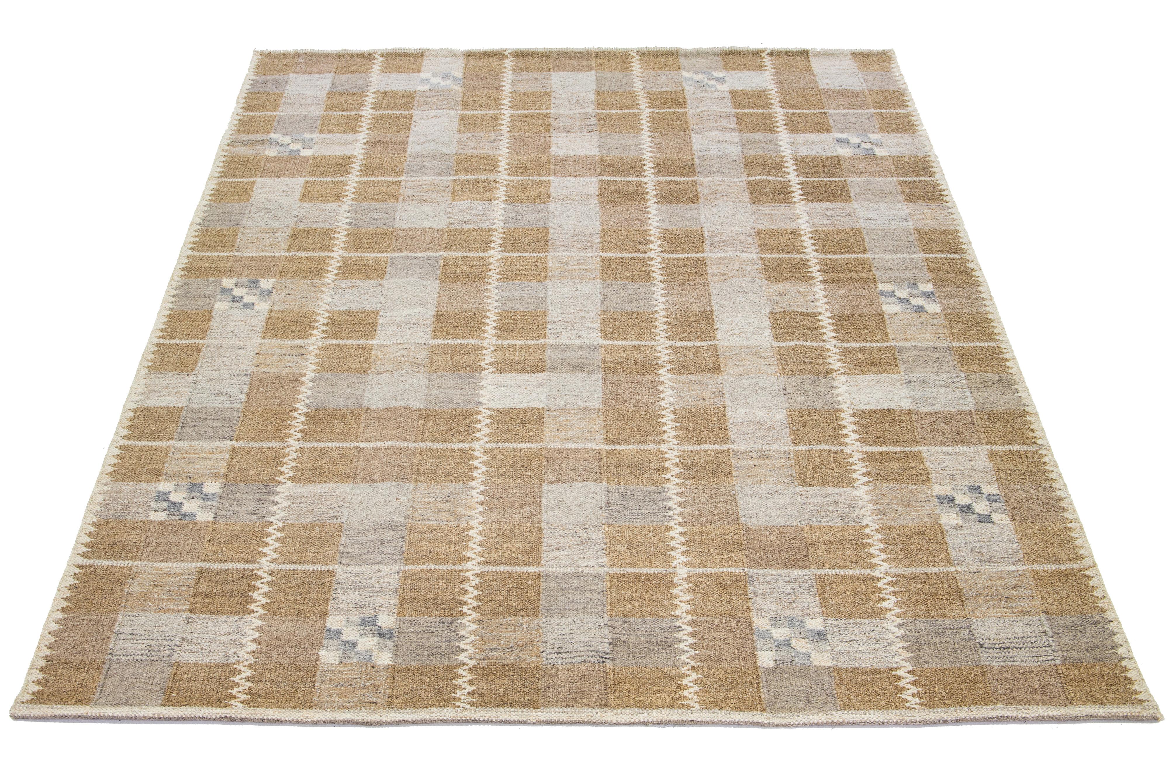 This modern woolen rug exhibits a remarkable tan foundation, flawlessly fusing Nordic-inspired design with exquisite geometric patterns containing delicate hints of gray and beige. The rug is crafted from a combination of wool and hemp, utilizing
