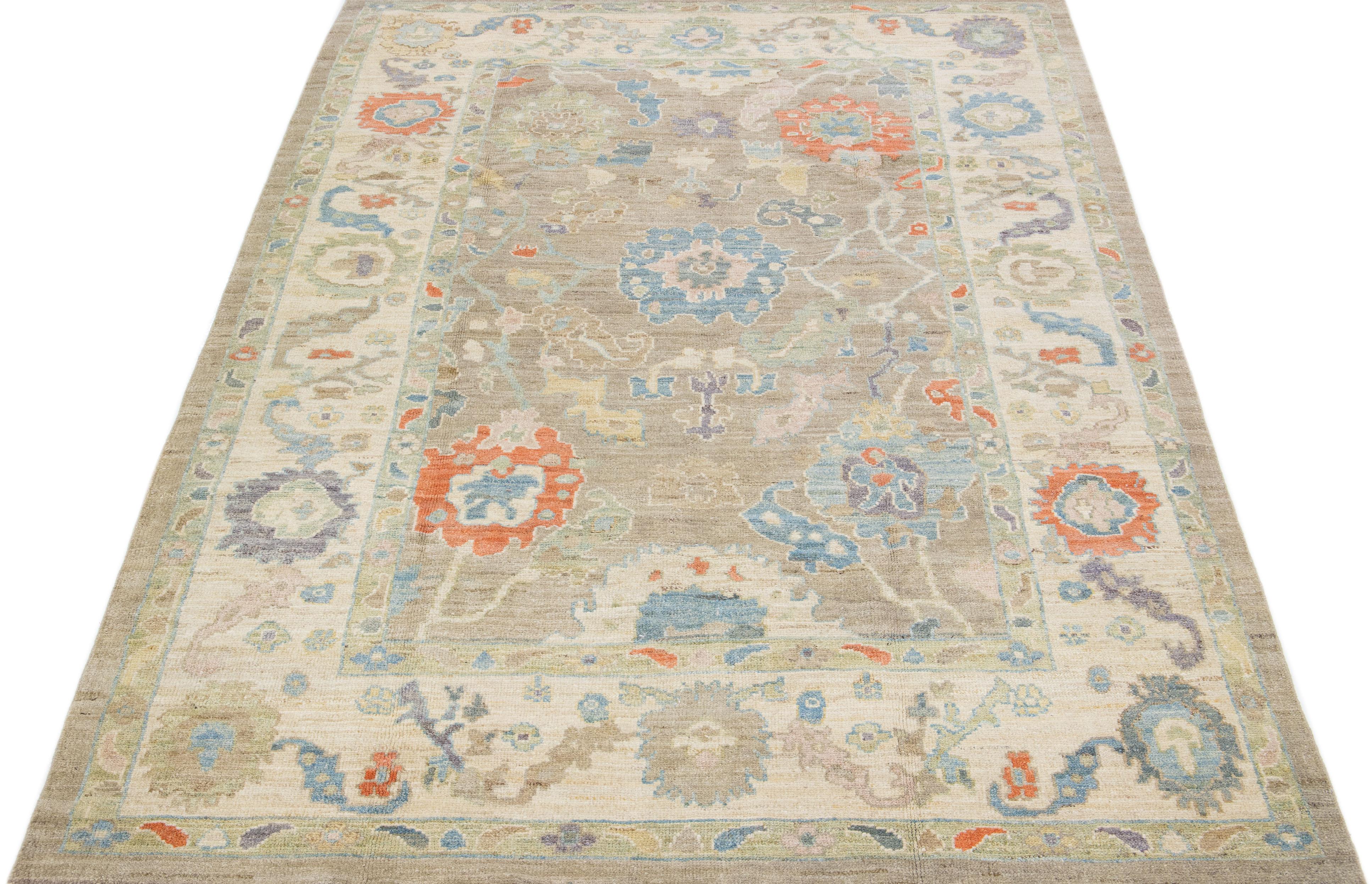 Beautiful modern Sultanabad hand-knotted wool rug with a tan color field. This rug has a designed frame with green, blue, and orange accents in a gorgeous all-over floral motif.

This rug measures: 6'5