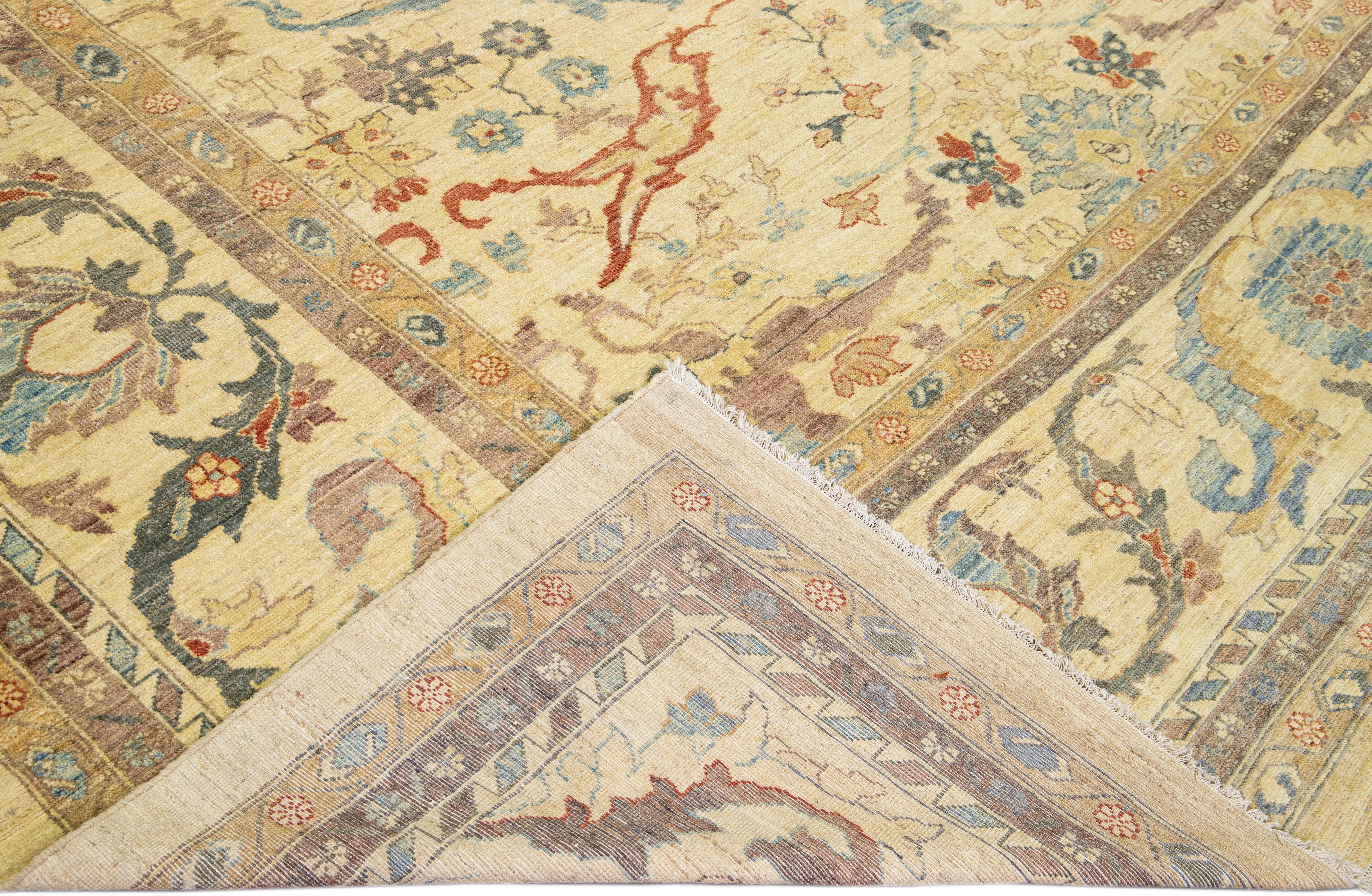 Beautiful modern Sultanabad hand-knotted wool rug with a beige field. This Sultanabad rug has brown, goldenrod, and blue accents in a gorgeous all-over classic floral pattern design.

This rug measures: 13'5