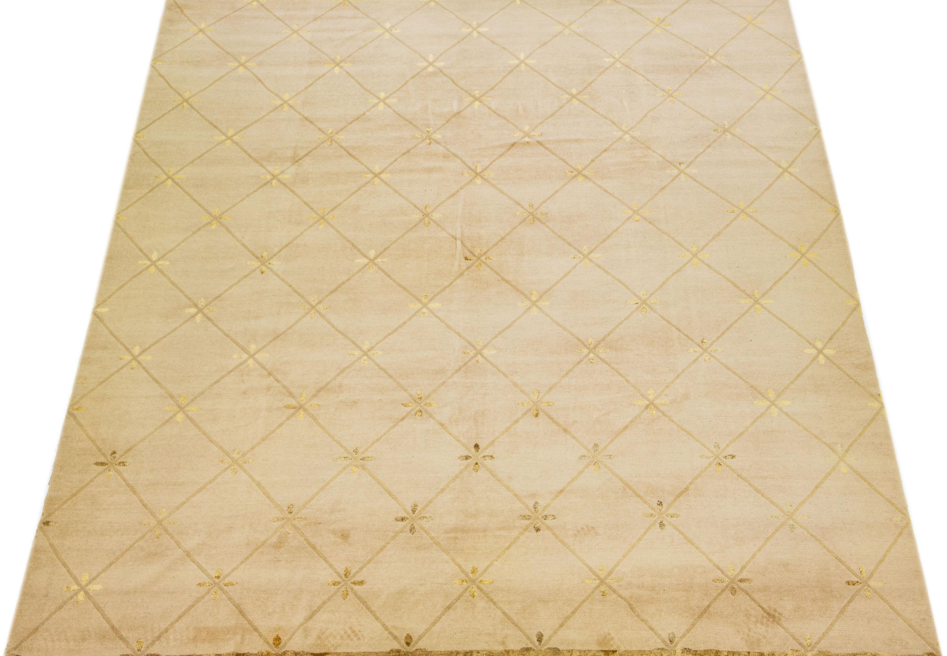 Schöner moderner tibetischer handgeknüpfter Wollteppich mit hellbraunem Farbfeld. Dieser nepalesische Teppich hat goldene Akzente und ein wunderschönes florales Allover-Muster.

Dieser Teppich misst 10' x 14'.