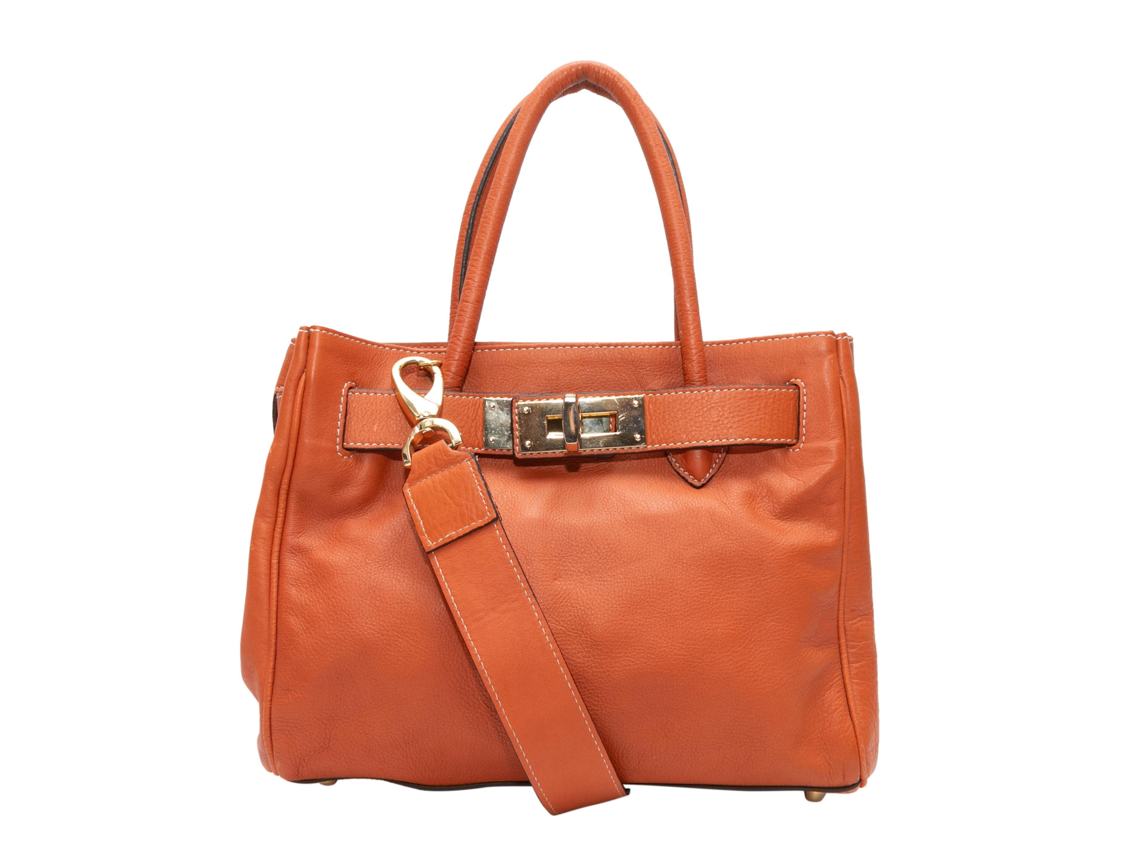 Dark Orange Suarez Small Leather Tote. This tote features a leather body, gold-tone hardware, contrast stitching, dual rolled top handles, an optional flat shoulder strap, and a top clasp closure. 12