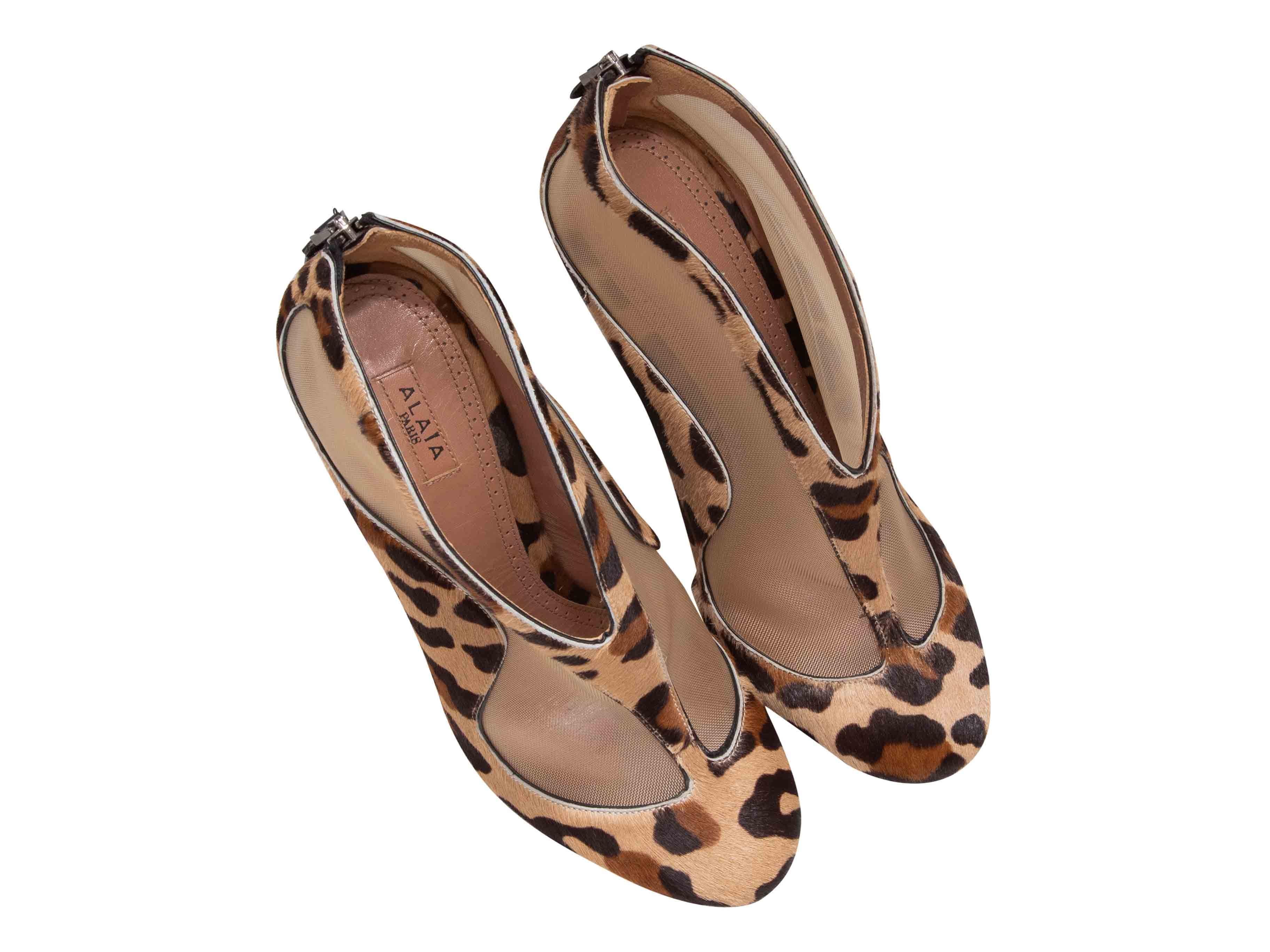 Tan, brown, and black leopard print ponyhair and mesh heeled booties by Alaia. Zip closure at counters. 4