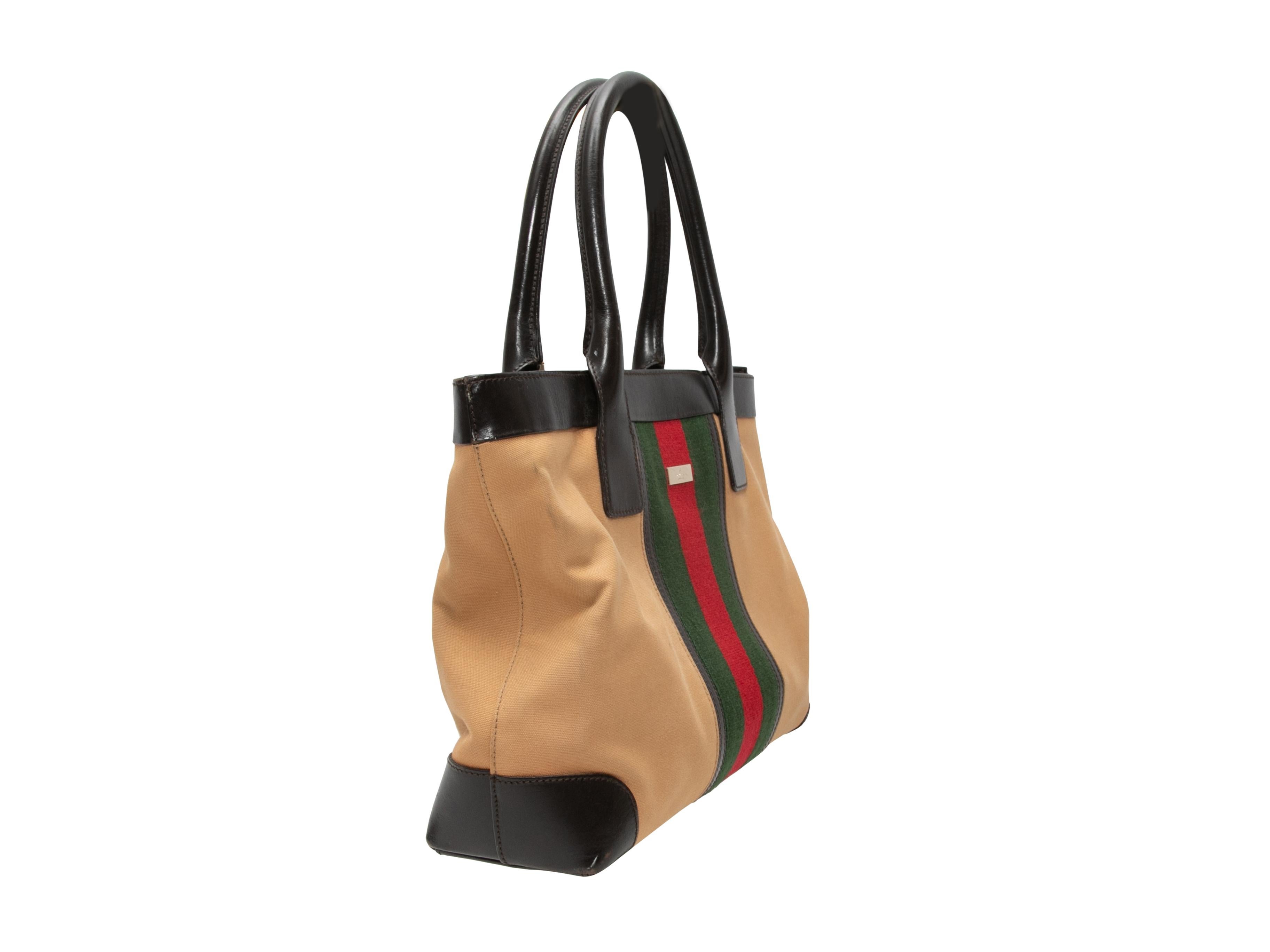 Product Details: Tan & Multicolor Gucci Web Tote Bag. This tote bag features a canvas body, leather trim, dual rolled top handles, and a top zip closure. 12