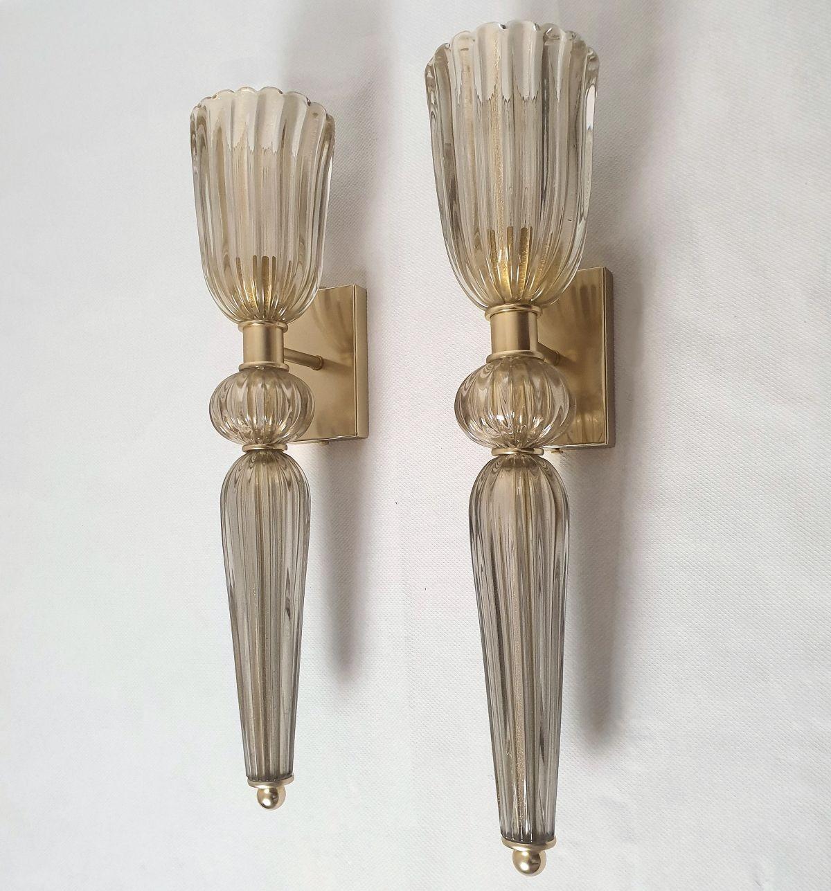 Pair of mid-century tall tan Murano Glass Sconces, attributed to Barovier, Italy 1970s.
The Torchiere style sconces are made of a hand blown thick tan color Murano glass.
The thickness of the glass makes it translucent; when lit they create a warm